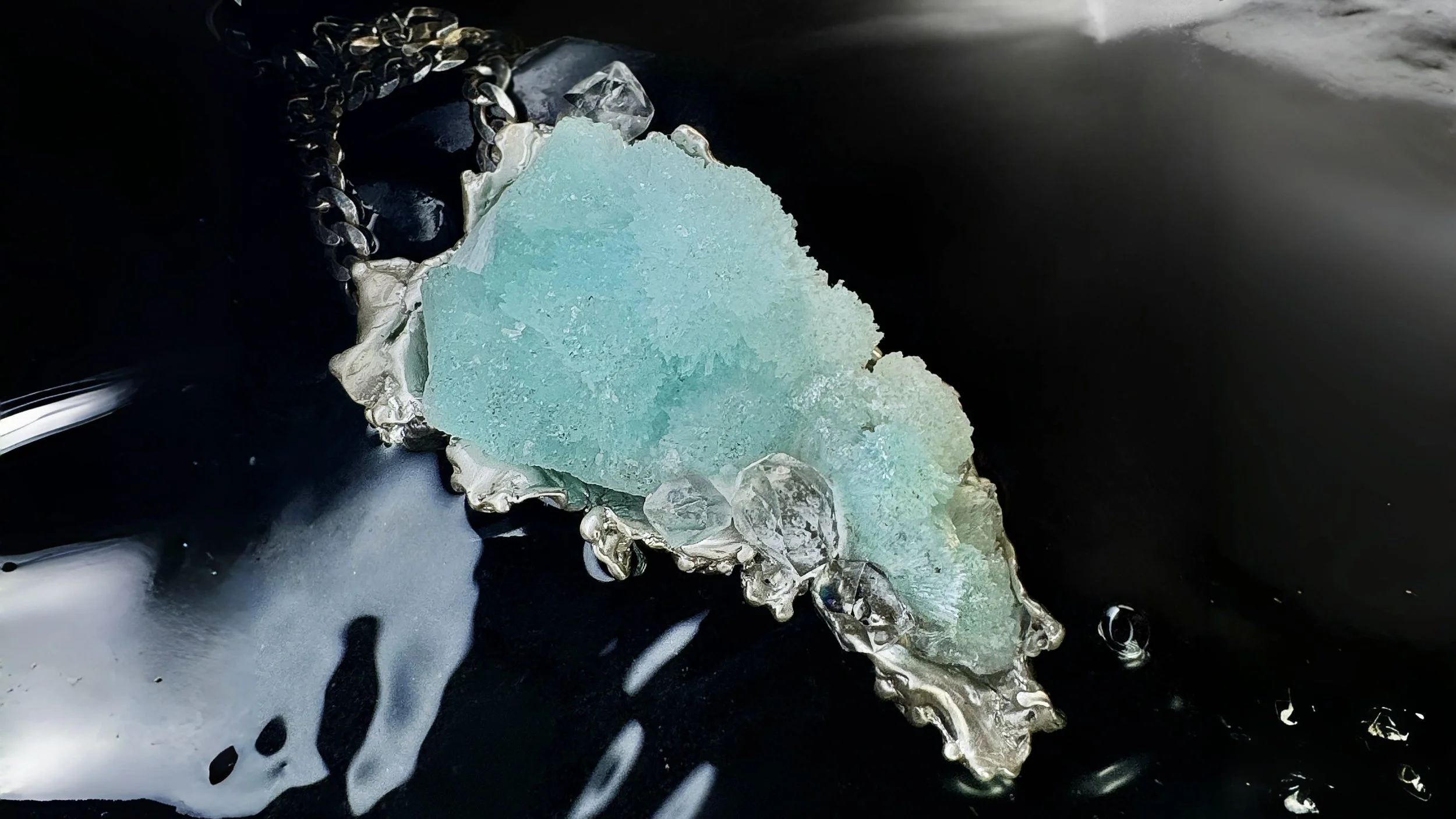 Large raw blue aragonite crystal encased by white gold sculptural waves and herkimer diamonds art necklace.