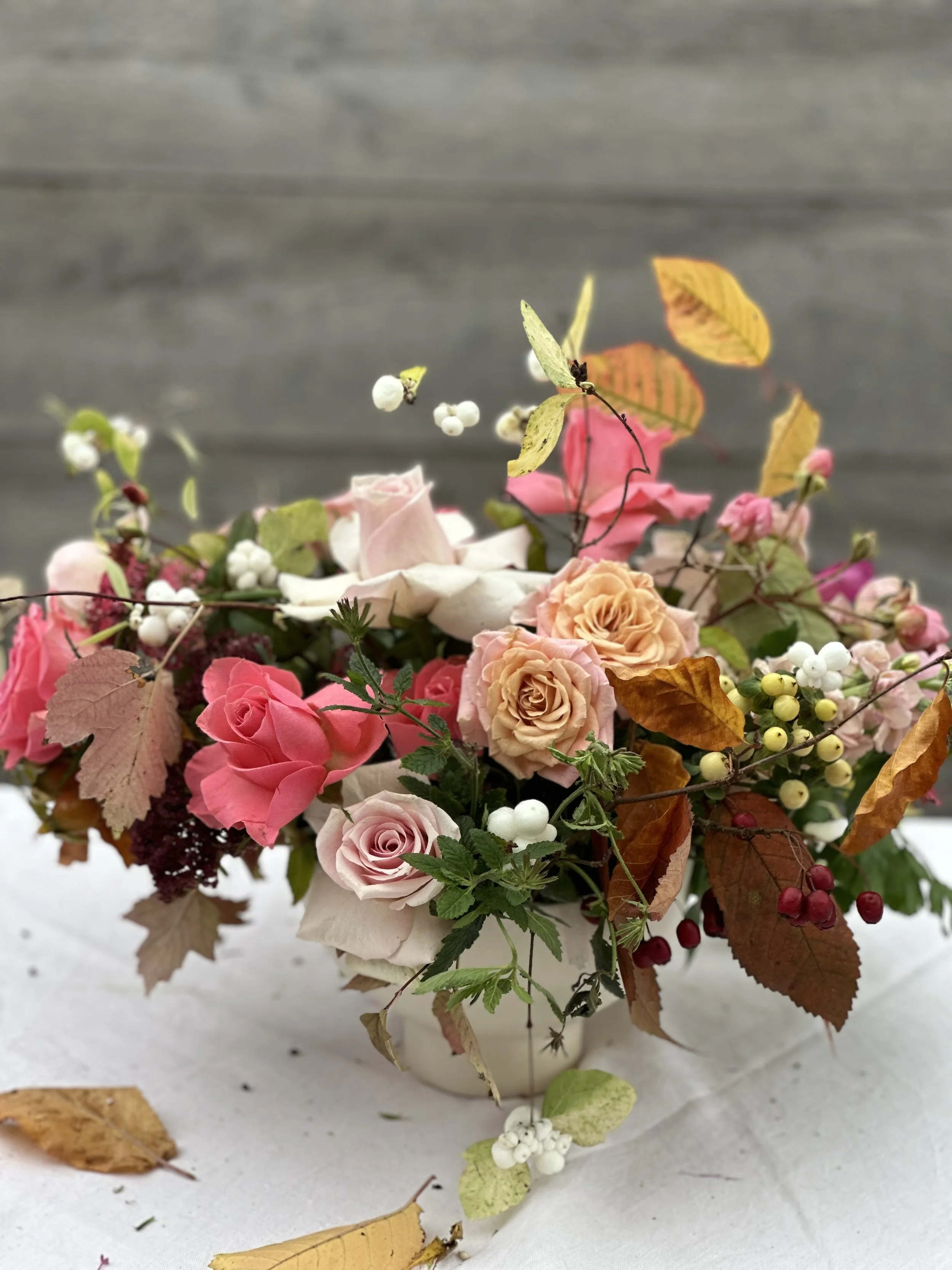 Autumn centrepiece with pink and blush roses, beech leaves, snowberries, and hawthorn by Foxgloves & Roses