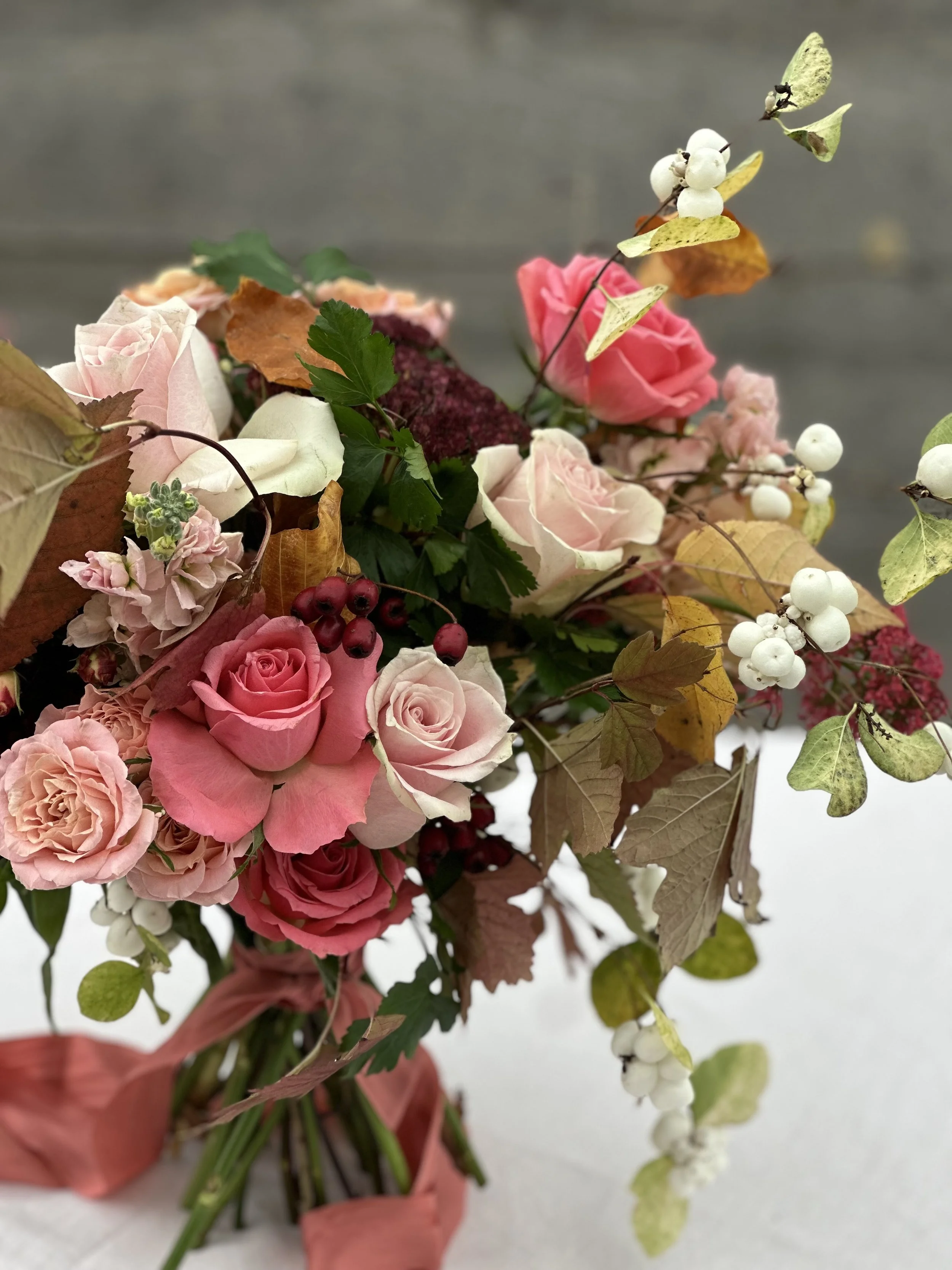 Autumn bouquet with pink and blush roses, beech leaves, snowberries, and hawthorn by Foxgloves & Roses