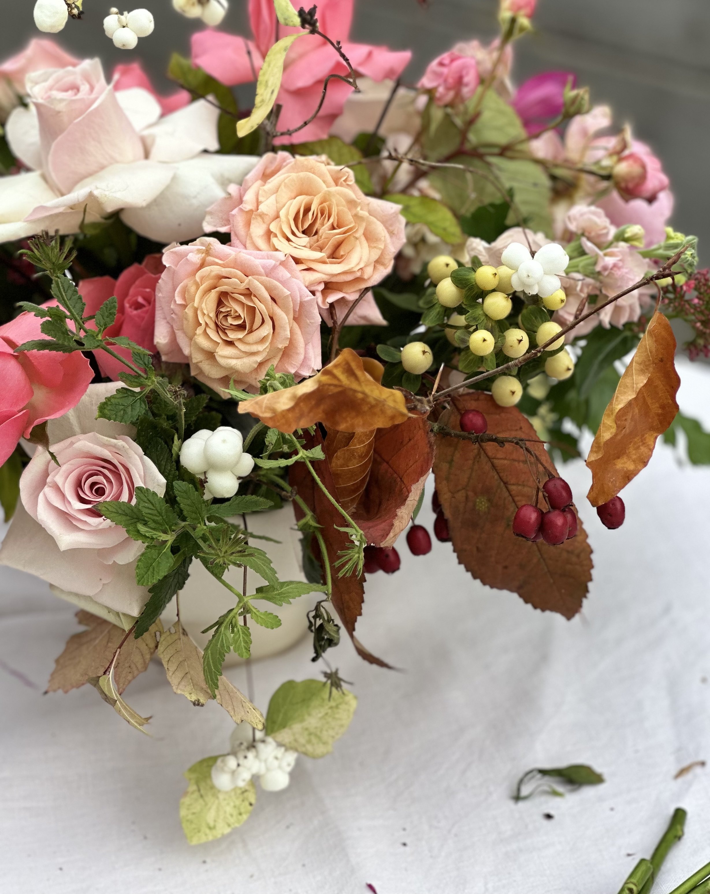 Autumn centrepiece with pink and blush roses, beech leaves, snowberries, and hawthorn by Foxgloves & Roses