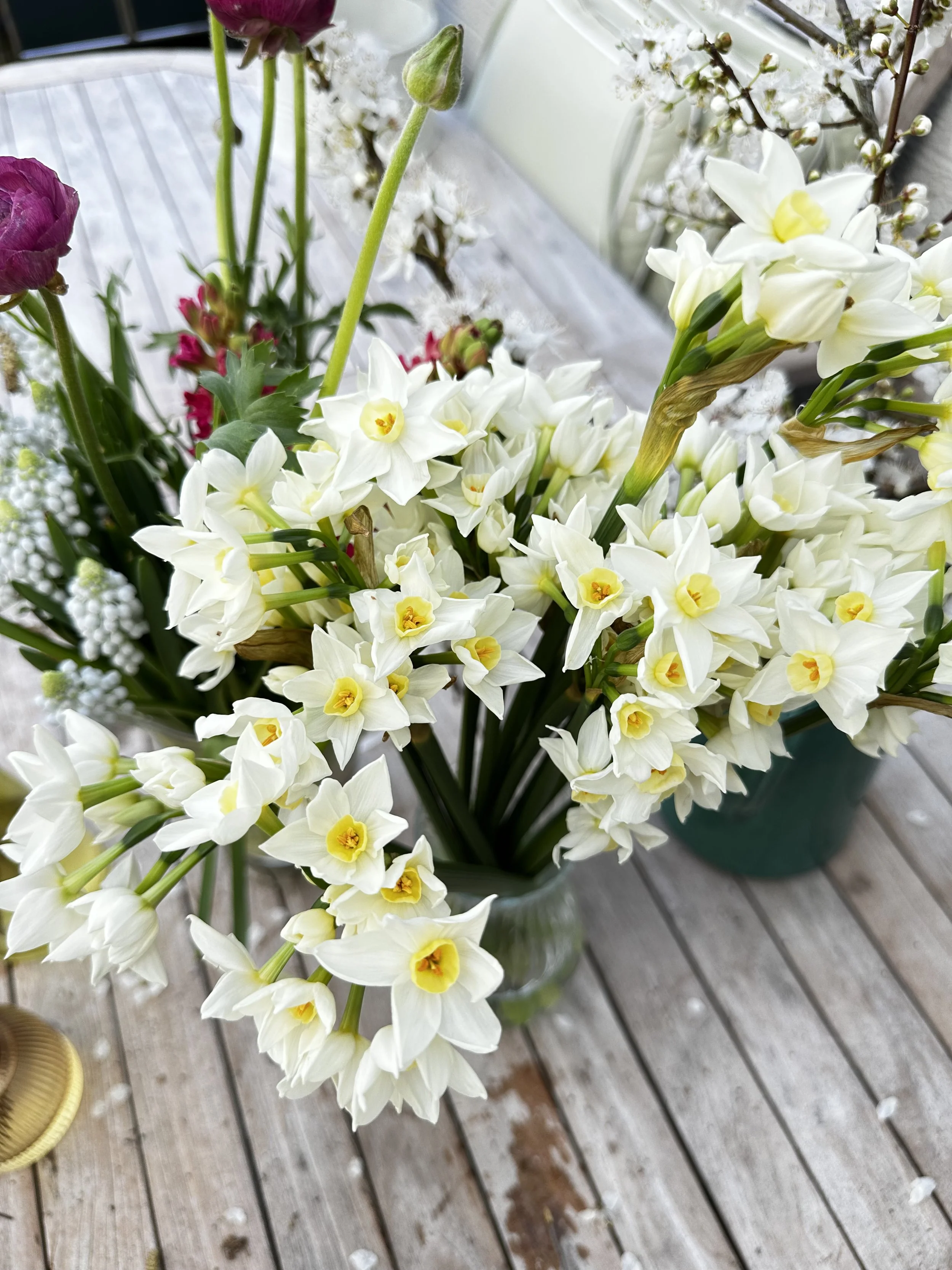 A bouquet of white and pink flowers arranged on a wooden surface.