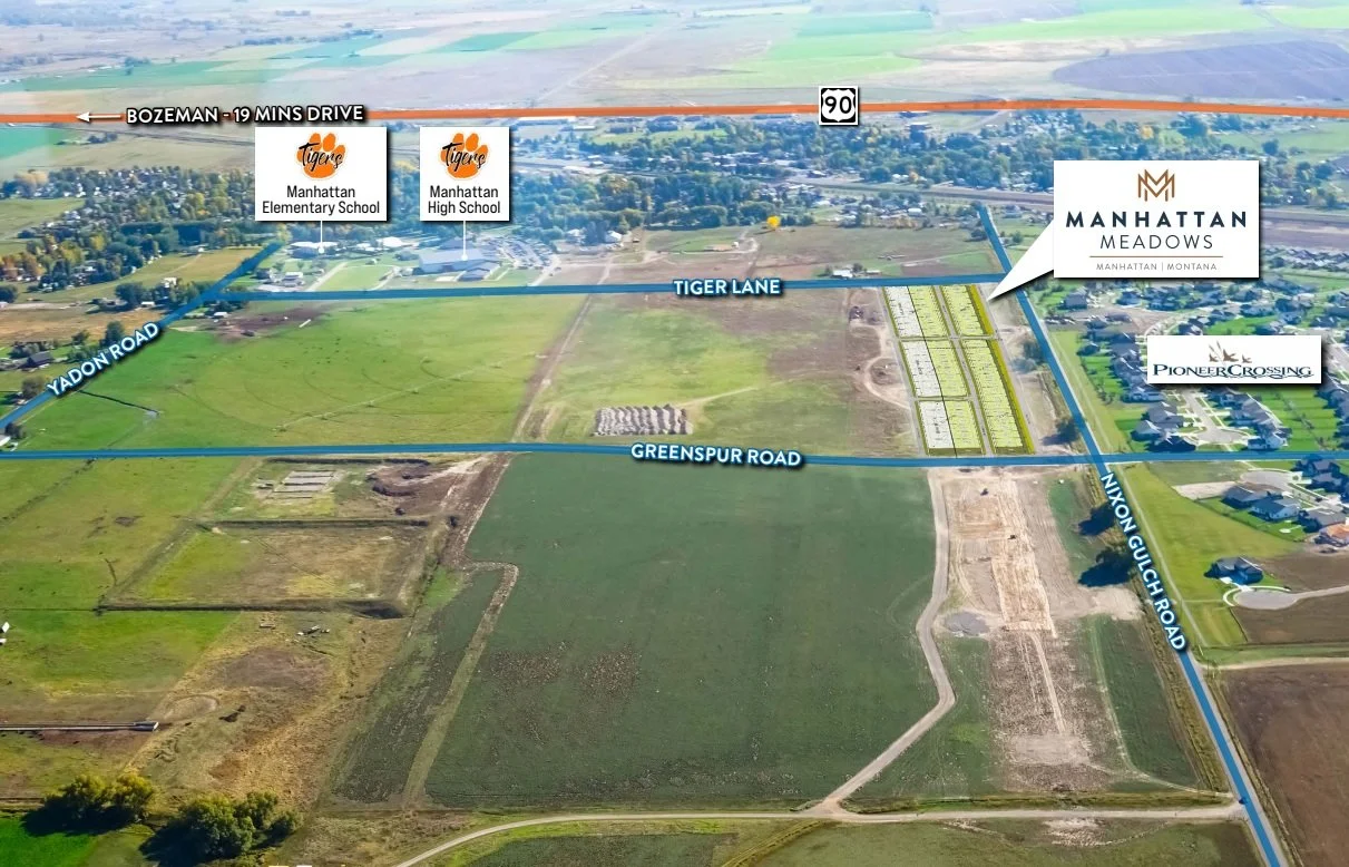 Aerial view of Manhattan Meadows development near Bozeman, Montana, showing roads including Greenspur Road, Tiger Lane, and TINYON GOUCH ROAD, with nearby schools like Manhattan Elementary and High Schools, and open fields.