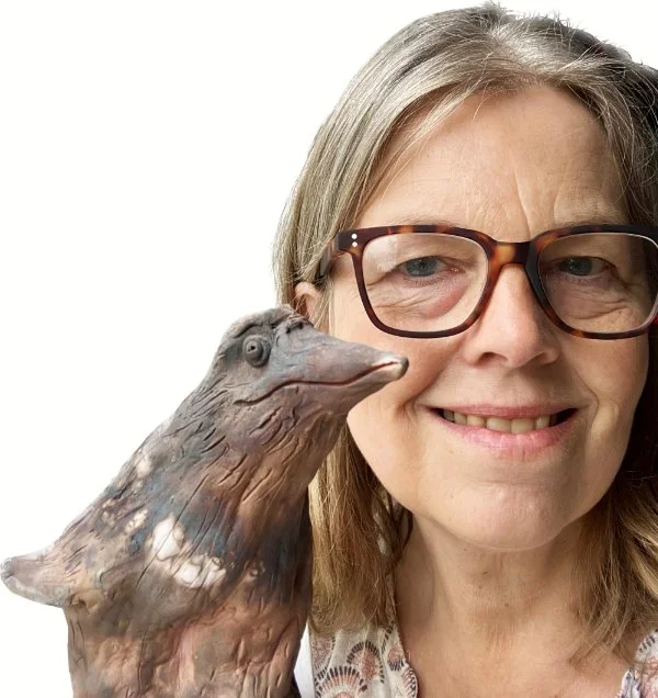 Caroline Whitehead with a smokefired ceramic figurine from her 'Puffguin' sculpture series