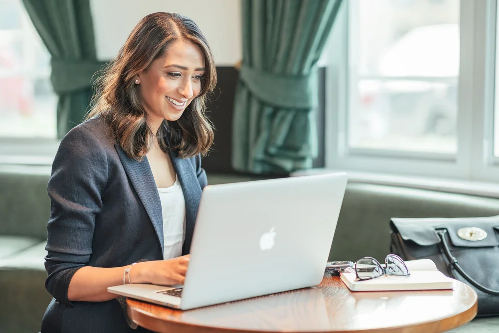 Dr Tajel Patel smiling while working at her laptop