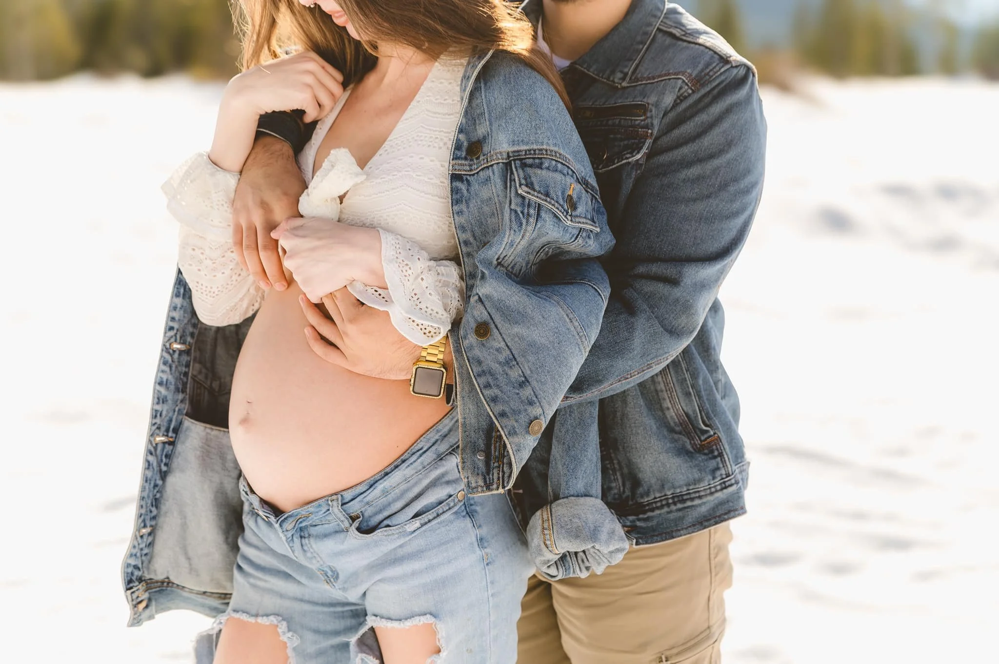 Close up of expectant parents embracing during a winter maternity session with denim outfits in the Pacific Northwest