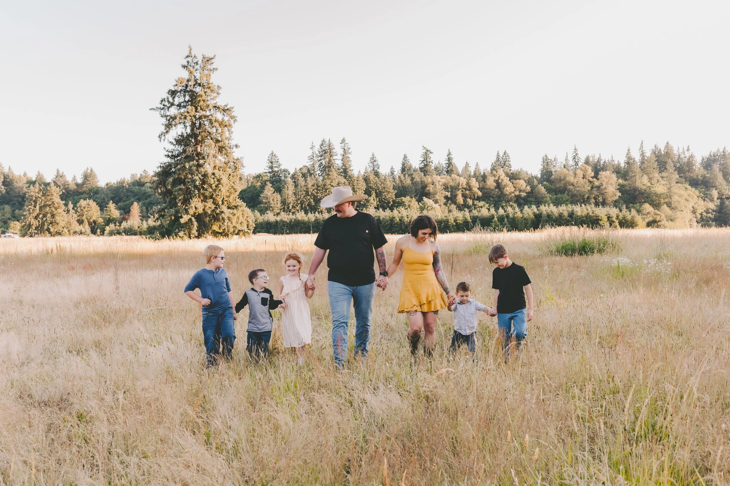 Family photographer in Vancouver WA capturing a relaxed outdoor family session with parents and children walking together