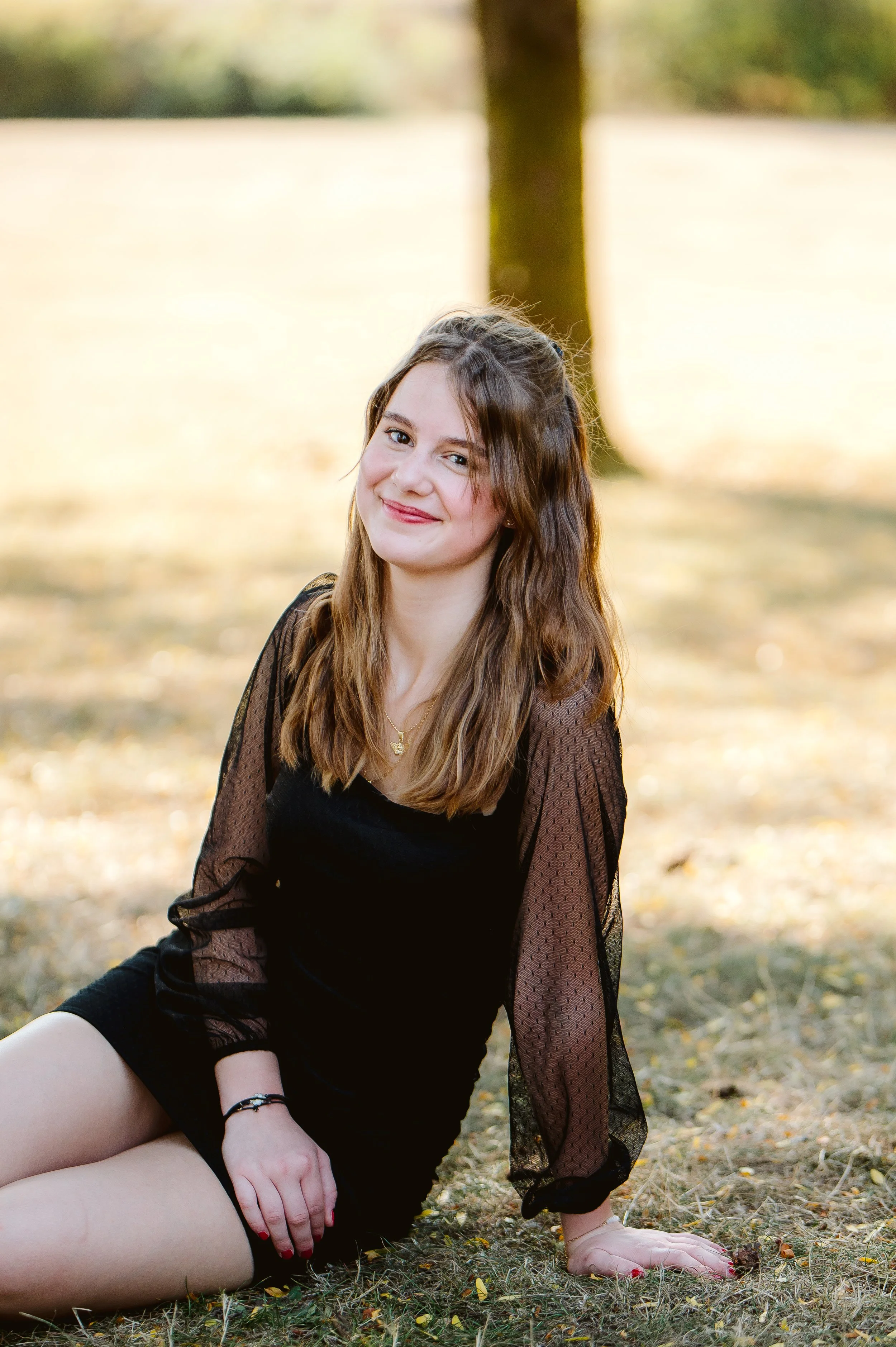 Outdoor senior portrait photographed in Vancouver Washington showcasing a seated pose and calm, natural styling