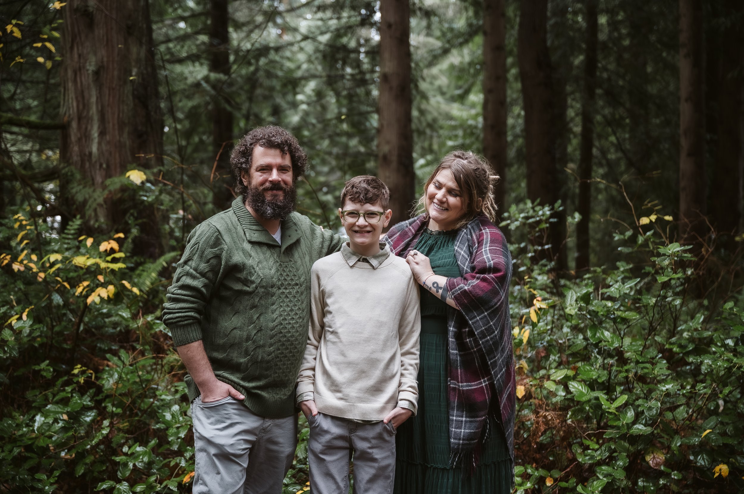 Family portrait photography in Oregon featuring parents and child together in a lush forest environment.
