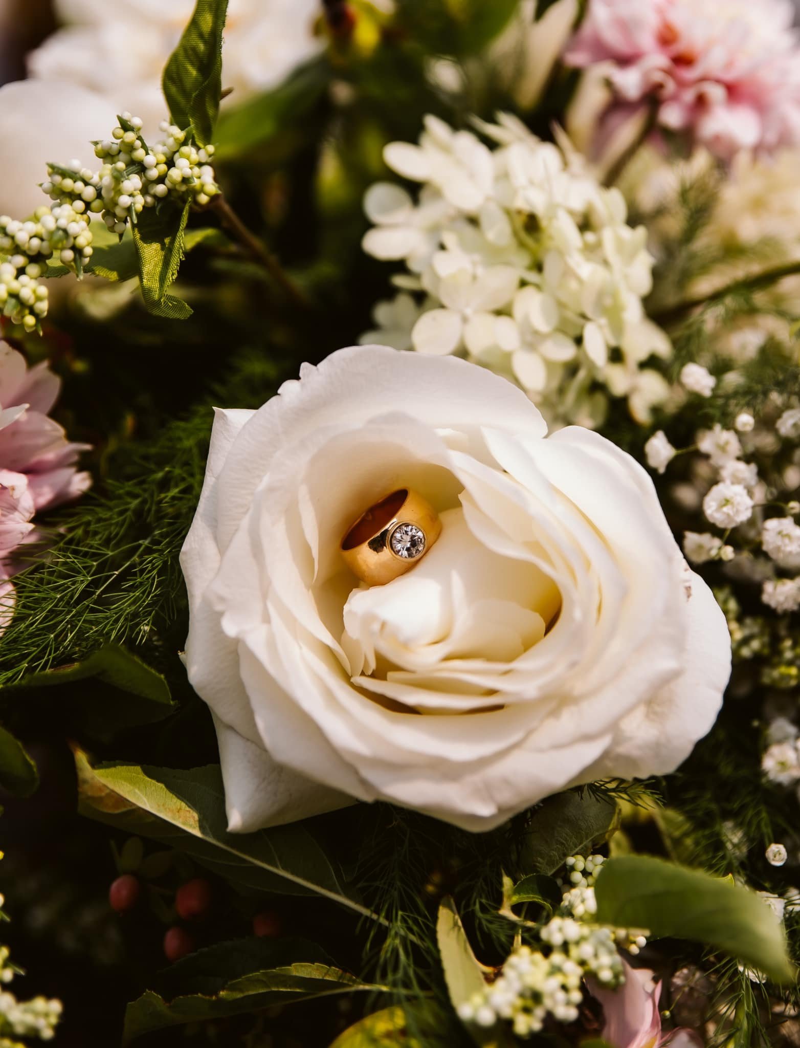 Wedding ring detail photographed in a white rose during an intimate wedding in The Dalles, Oregon near the Columbia River Gorge.