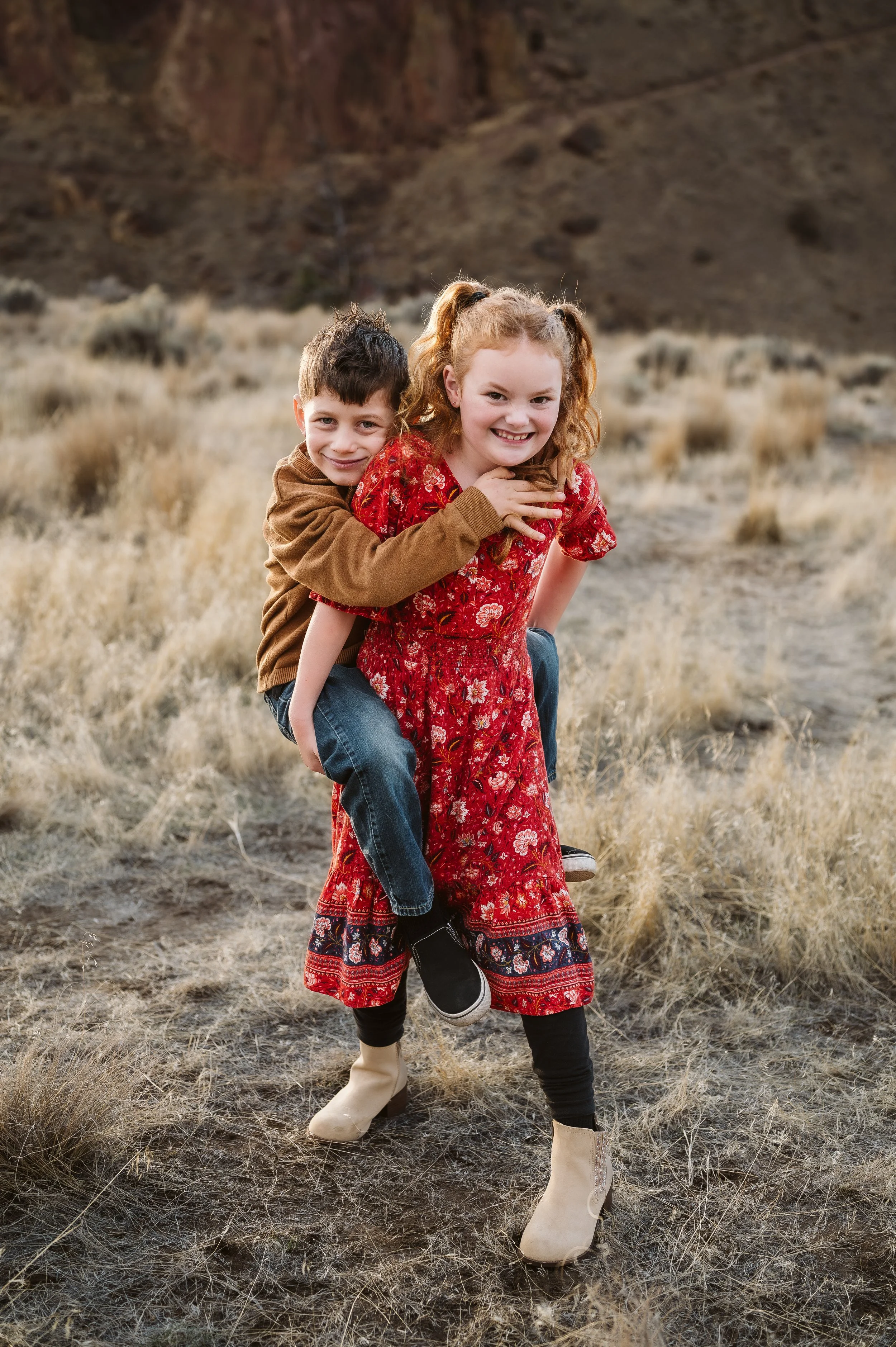 Sibling photography in Oregon documenting playful connection and laughter during a candid outdoor family session.