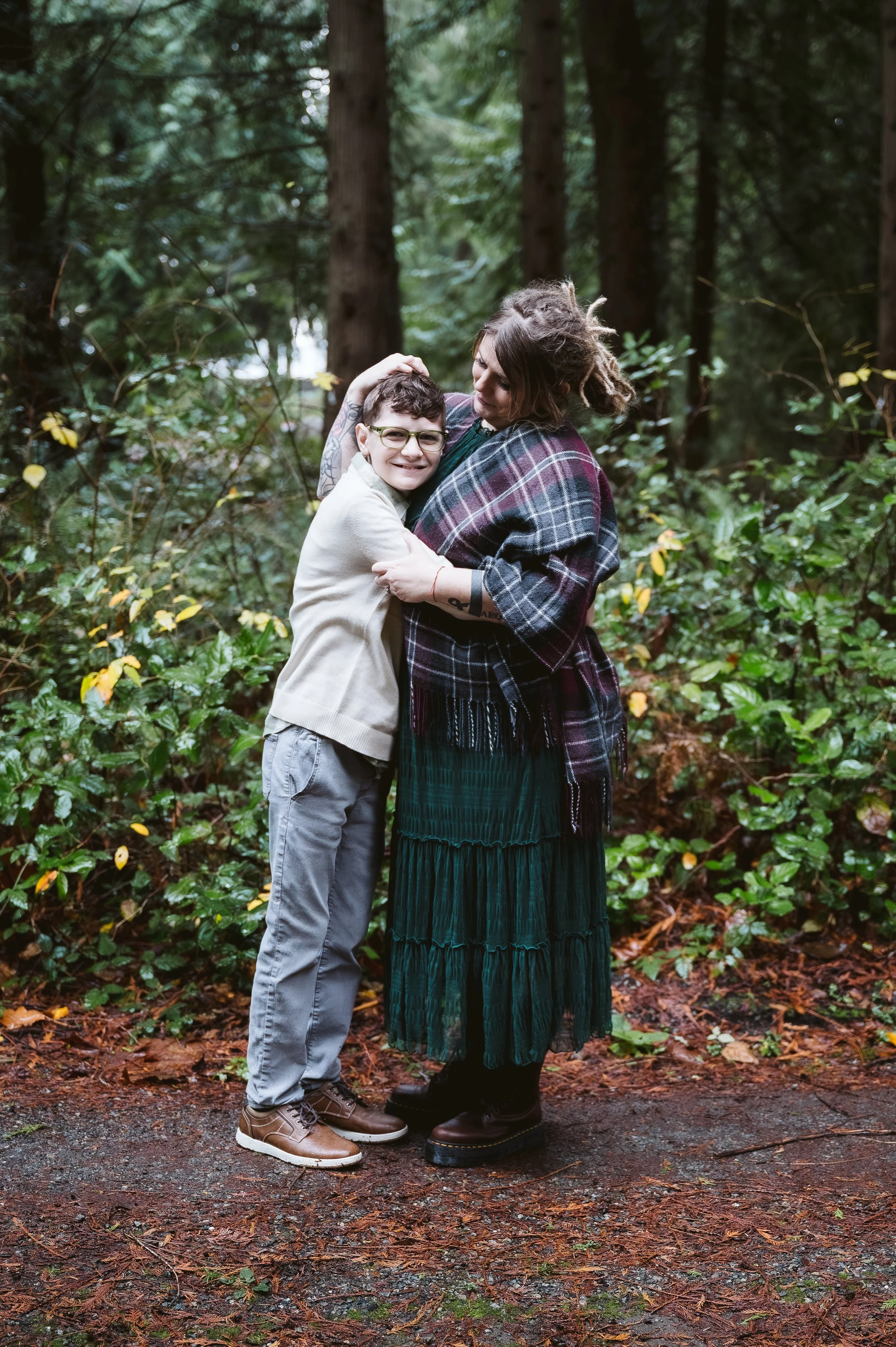 Candid family photography in Oregon capturing a tender hug between parent and child during an intimate forest session.