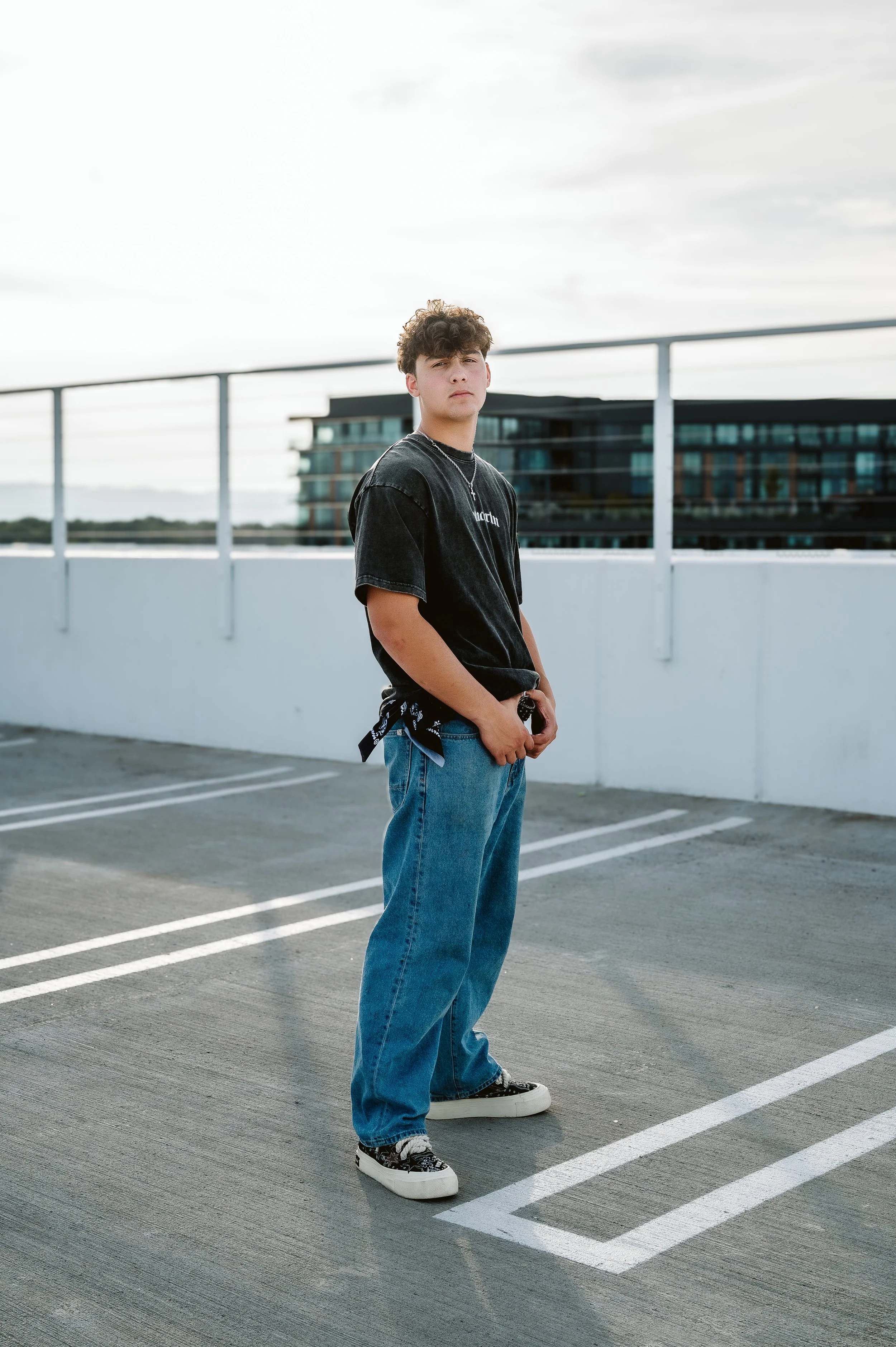 Outdoor senior photography portrait in Vancouver Washington featuring a casual pose with soft light and a modern environment.
