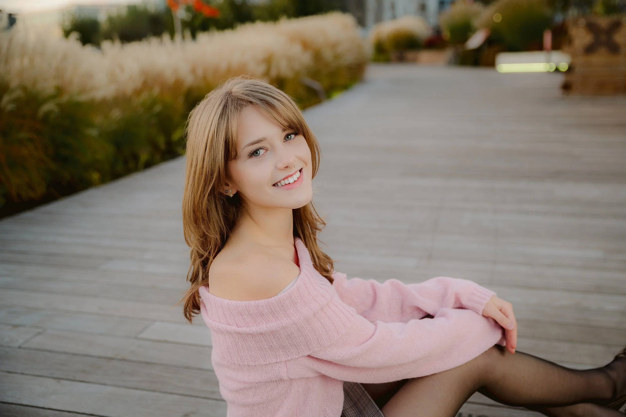 High school senior in a pink sweater posing outdoors for senior photos in Vancouver WA