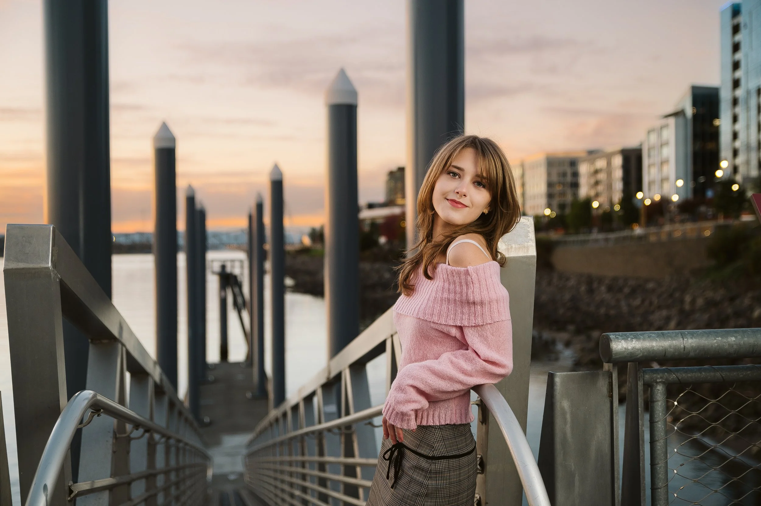 High school senior in a pink sweater posing at sunset along the Vancouver Washington waterfront