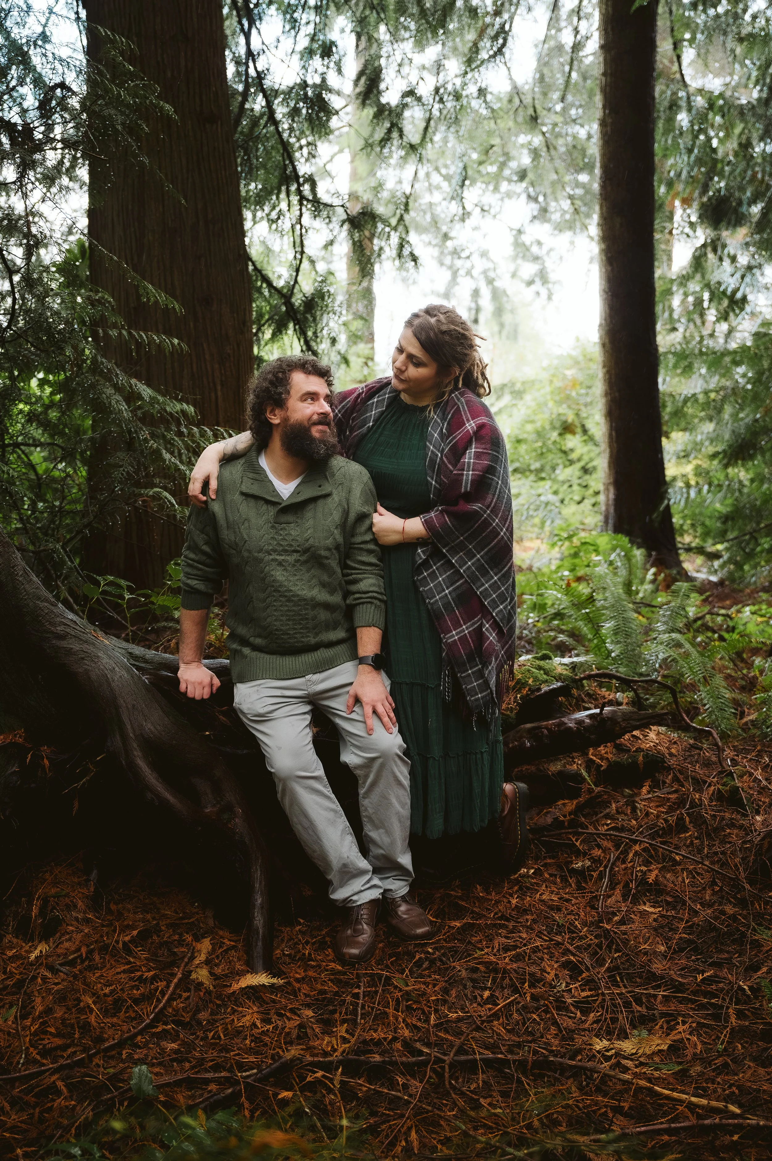 Outdoor couples photography session in Vancouver Washington featuring a relaxed moment together in a forest setting.
