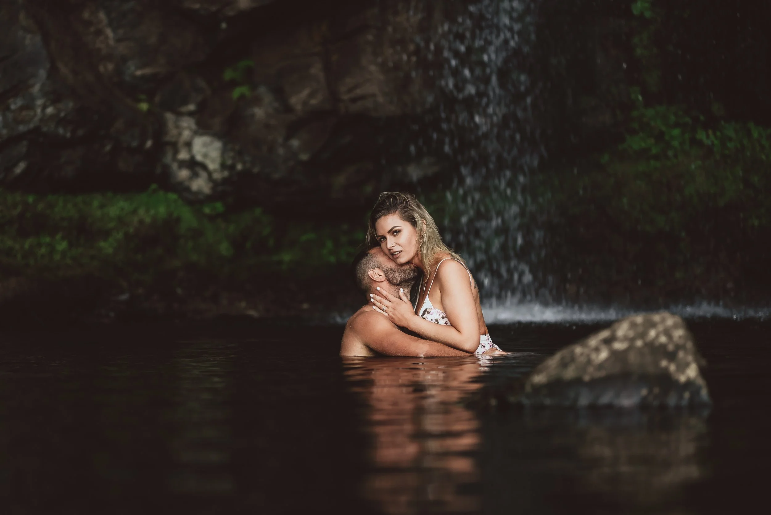 Couple embracing in the water during an intimate waterfall elopement in Washington State