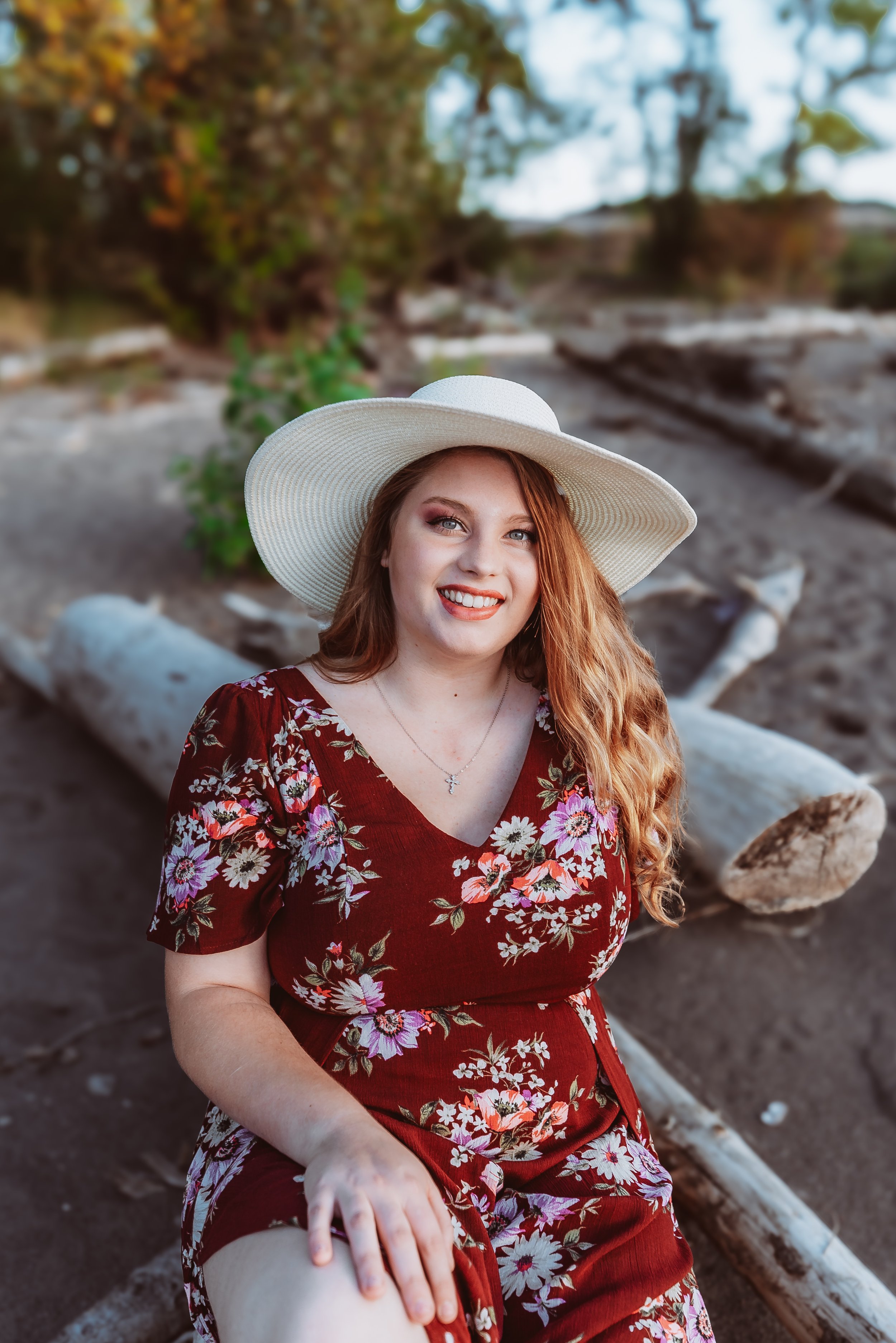 Outdoor senior portrait session in Vancouver Washington showcasing a confident high school graduate posed on driftwood with soft natural light.