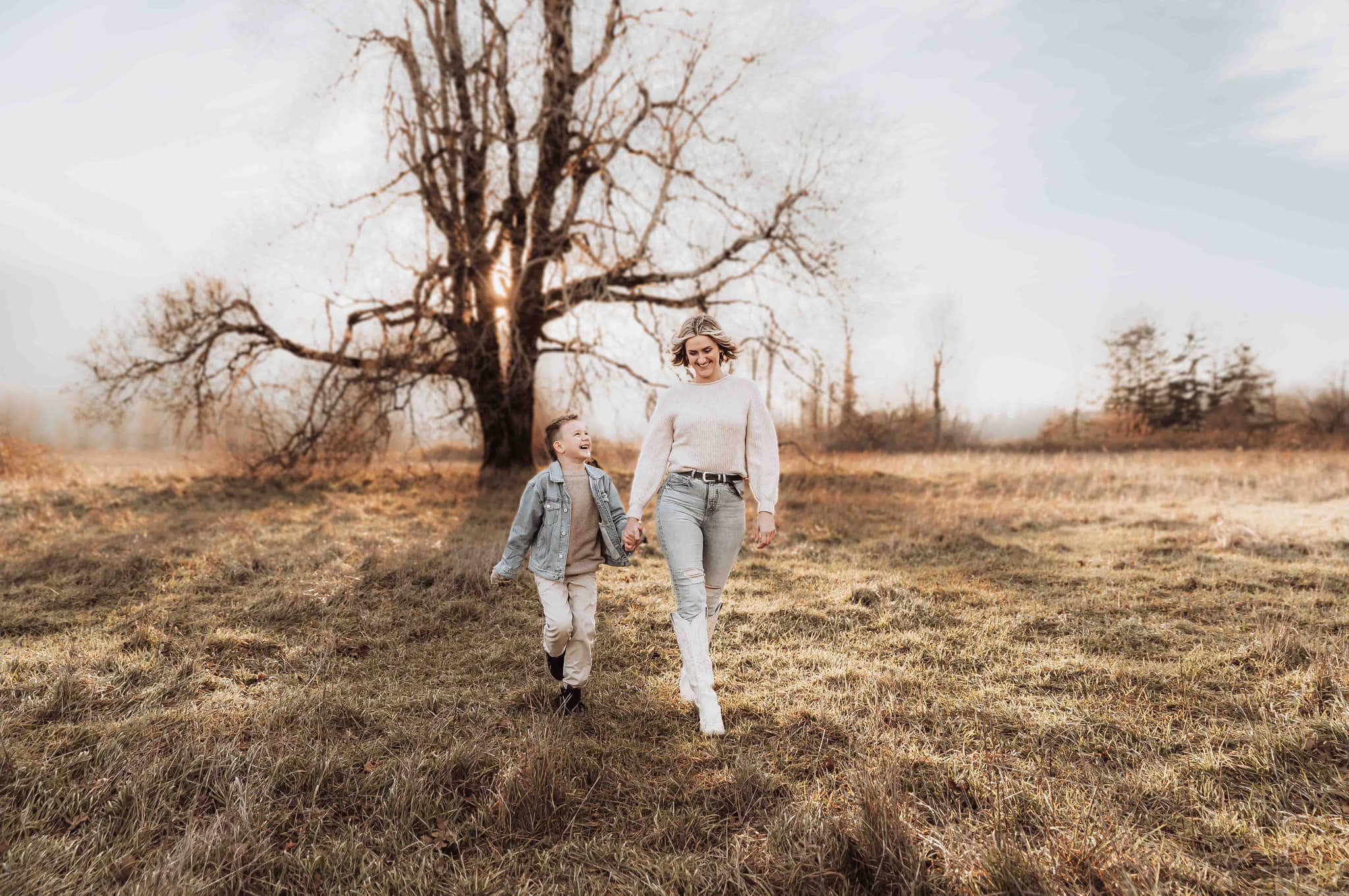 Mother and child walking hand in hand through a quiet winter field in the Pacific Northwest during a Vancouver Washington family photography session