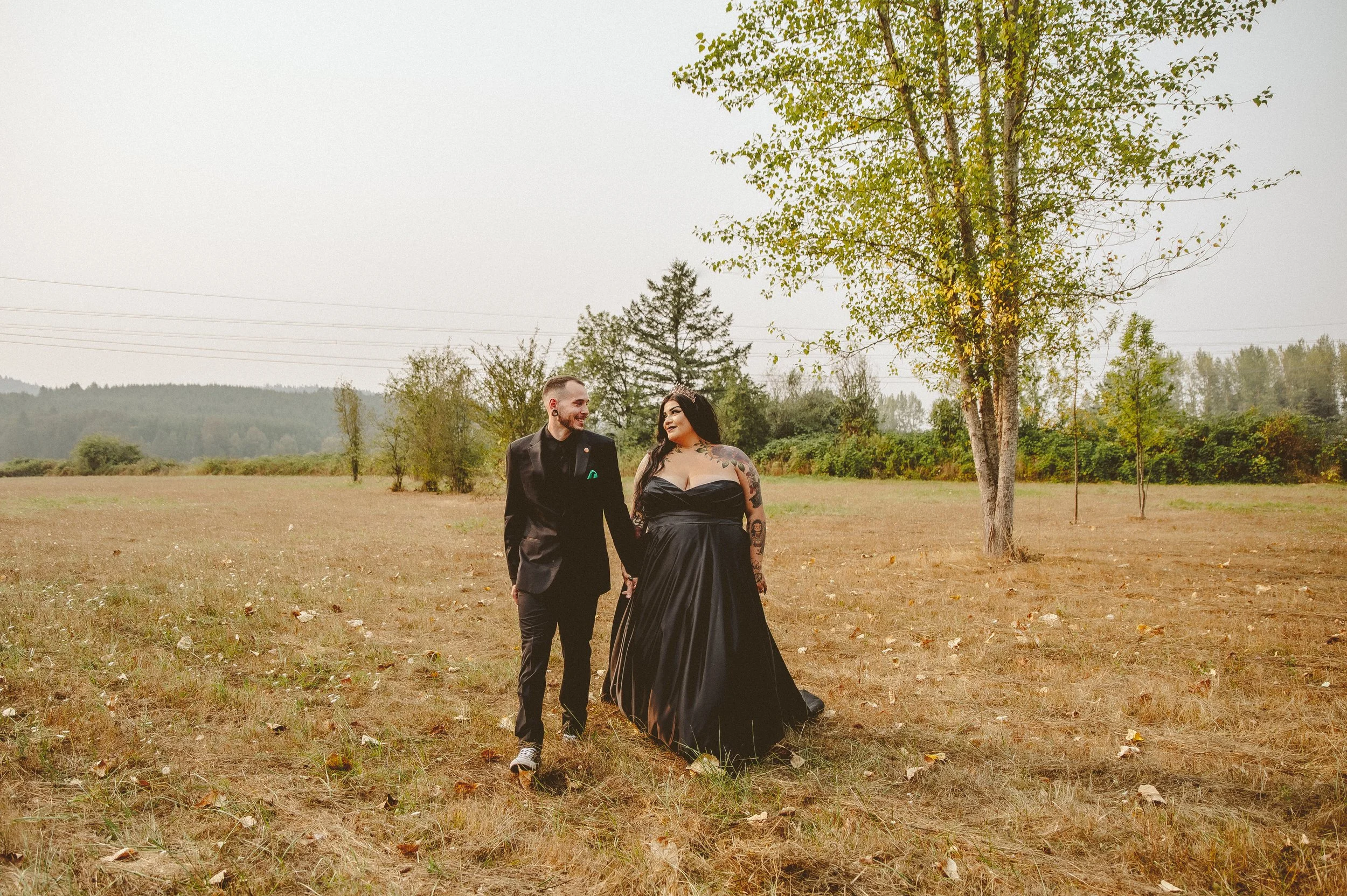 couple walking together during an intimate oregon elopement in an open field natural candid wedding moment