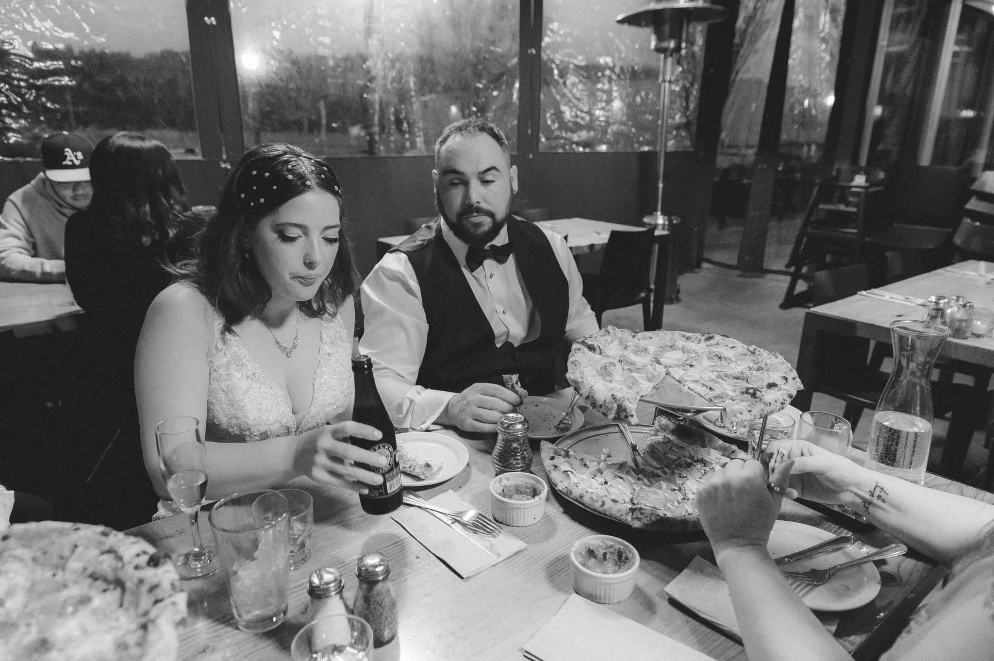 Bride and groom eating pizza together after a New Year’s Eve elopement