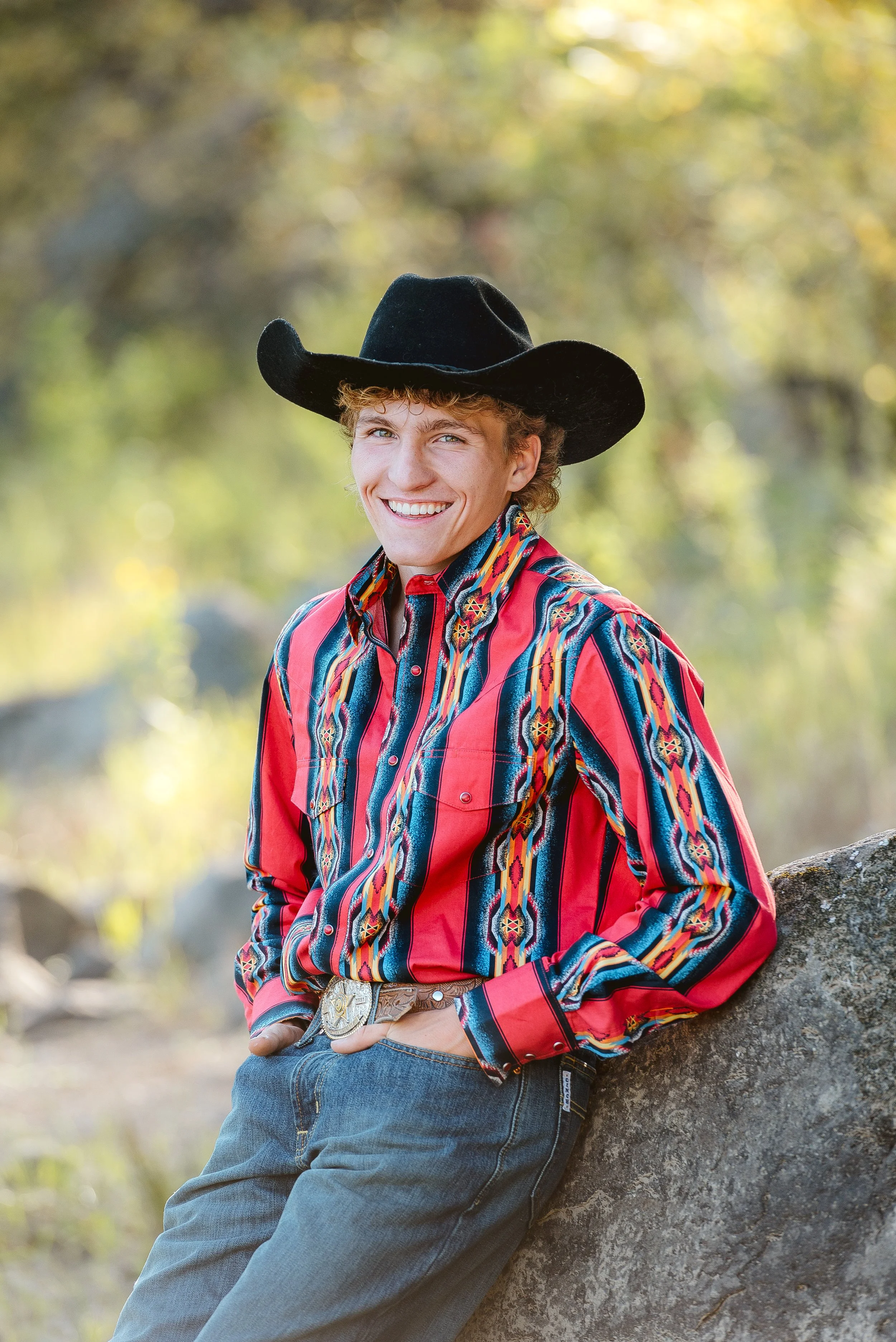 High school senior wearing a cowboy hat and western shirt for outdoor senior portraits near Vancouver WA