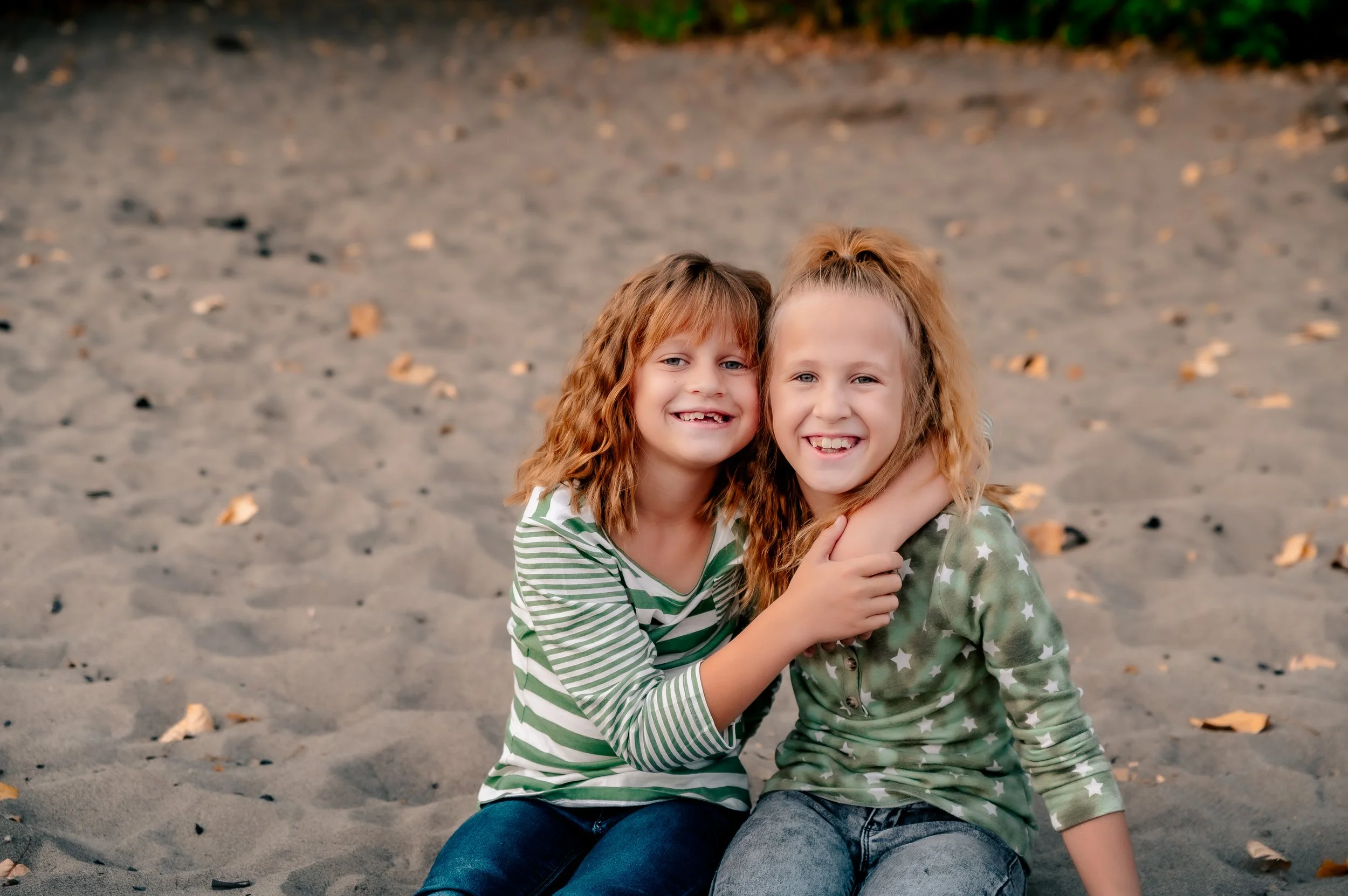 Two young siblings smiling and hugging during a family photo session in Vancouver Washington