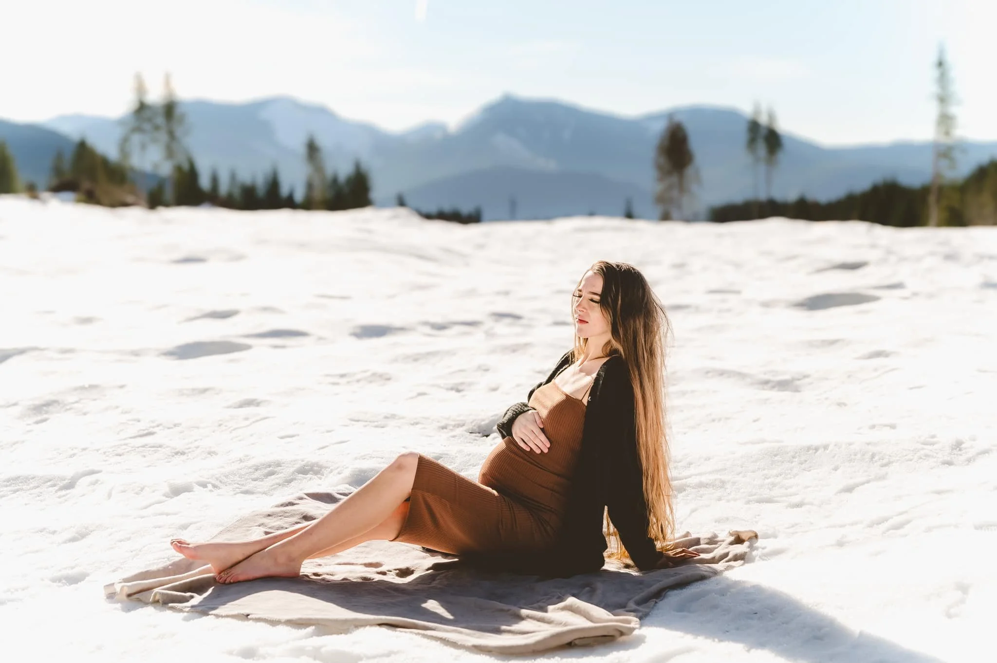 Solo maternity portrait taken outdoors in winter light in Vancouver WA with snow and mountains in the background