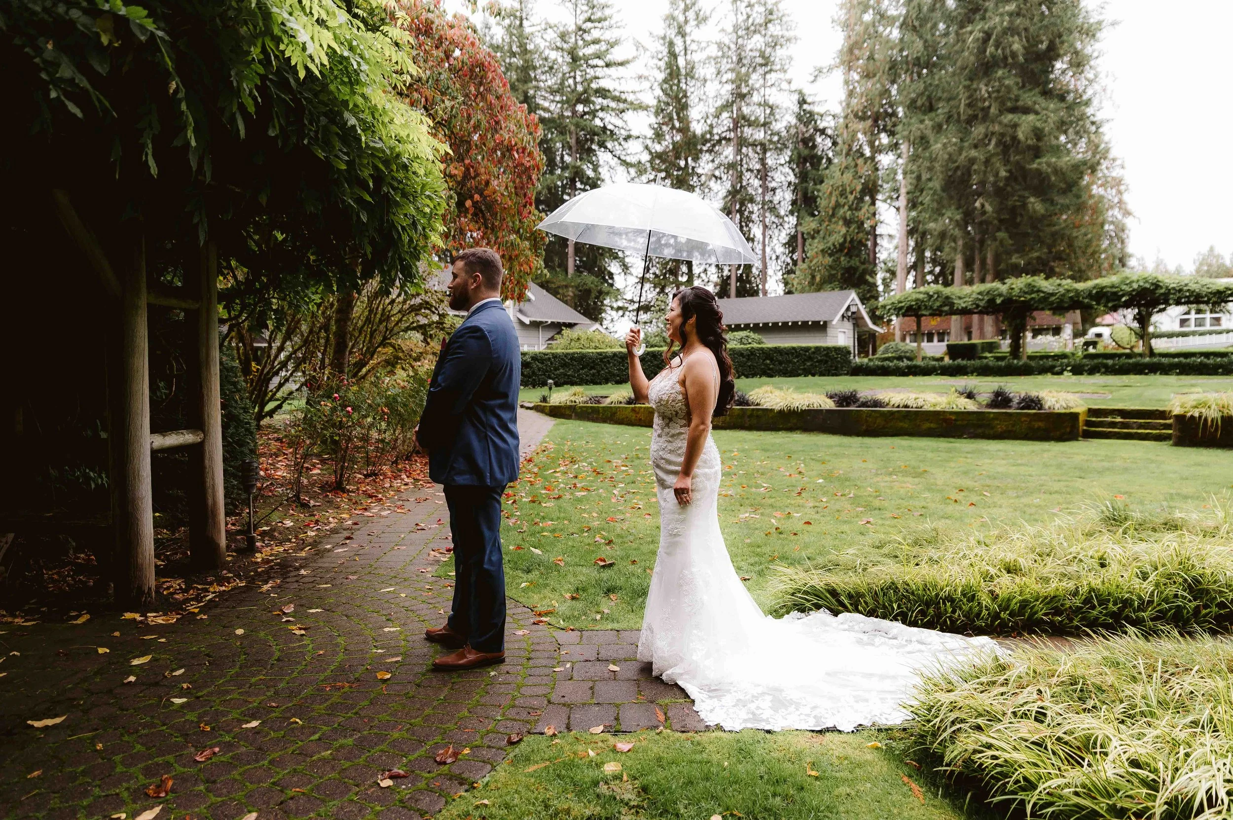 couple sharing a first look moment in a garden during an intimate oregon wedding on a rainy day