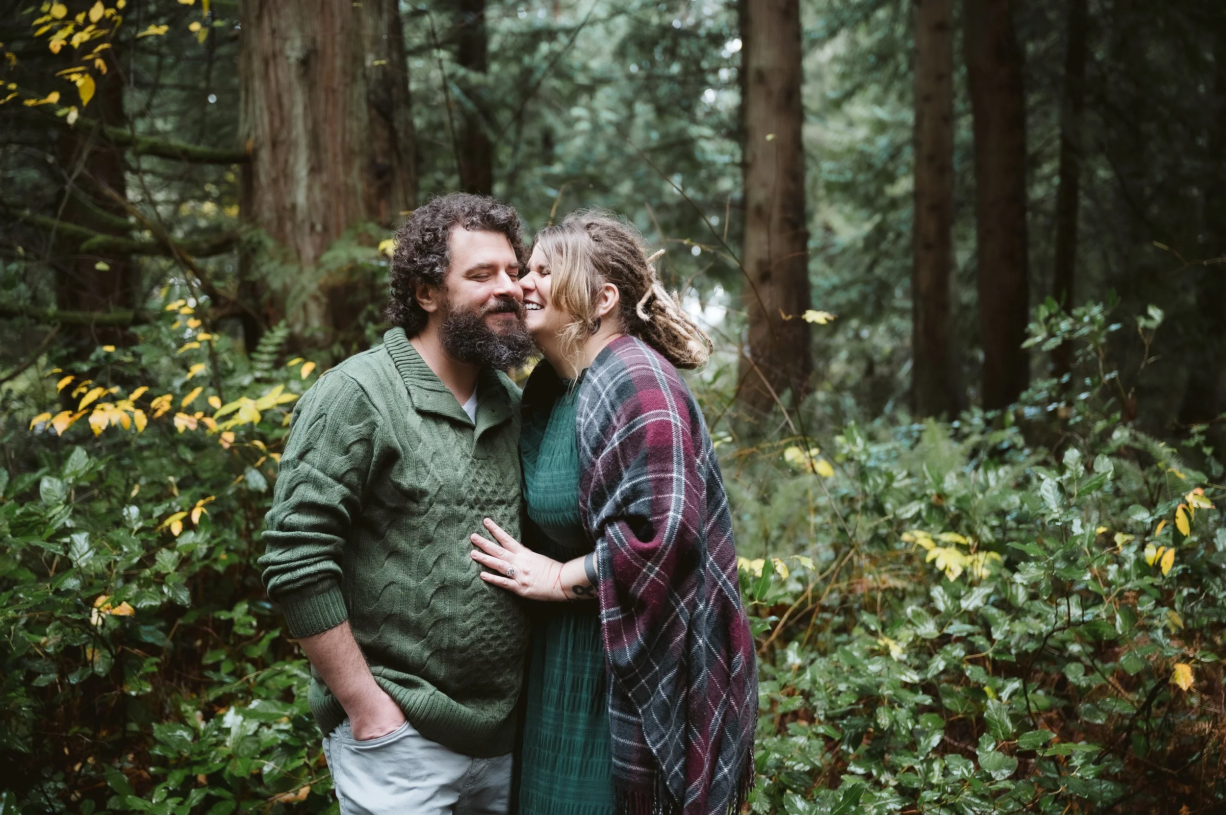 Couples photography session in Vancouver Washington featuring a relaxed, candid moment together in a wooded outdoor setting.
