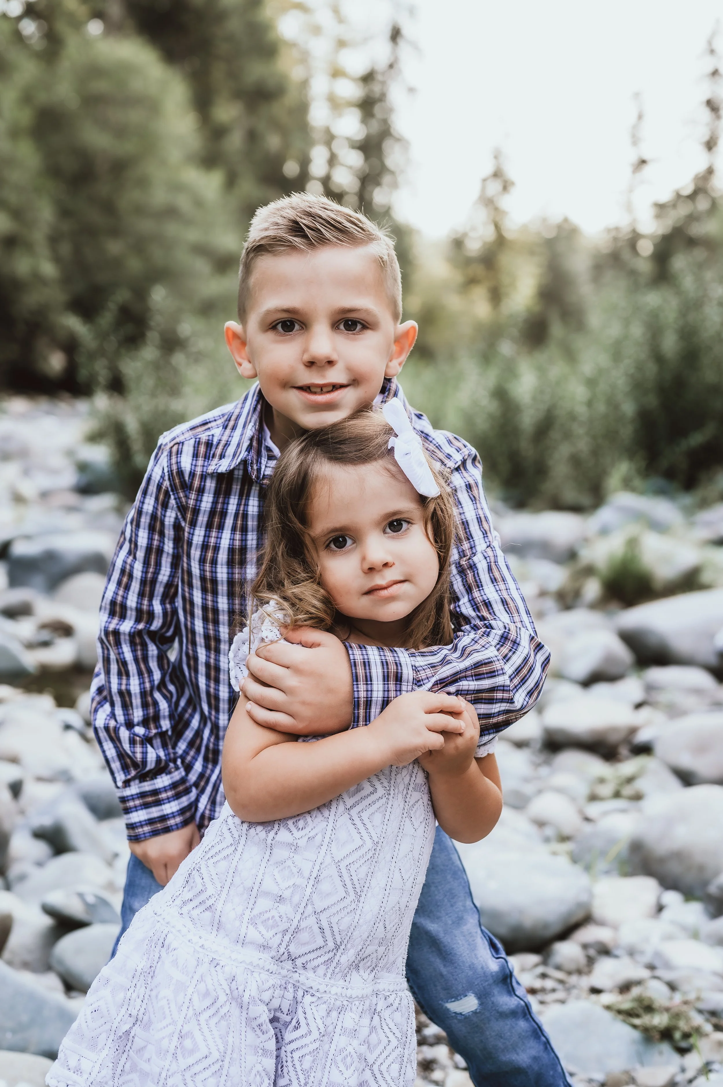 Sibling hugging during a relaxed outdoor family photo session in Vancouver, Washington