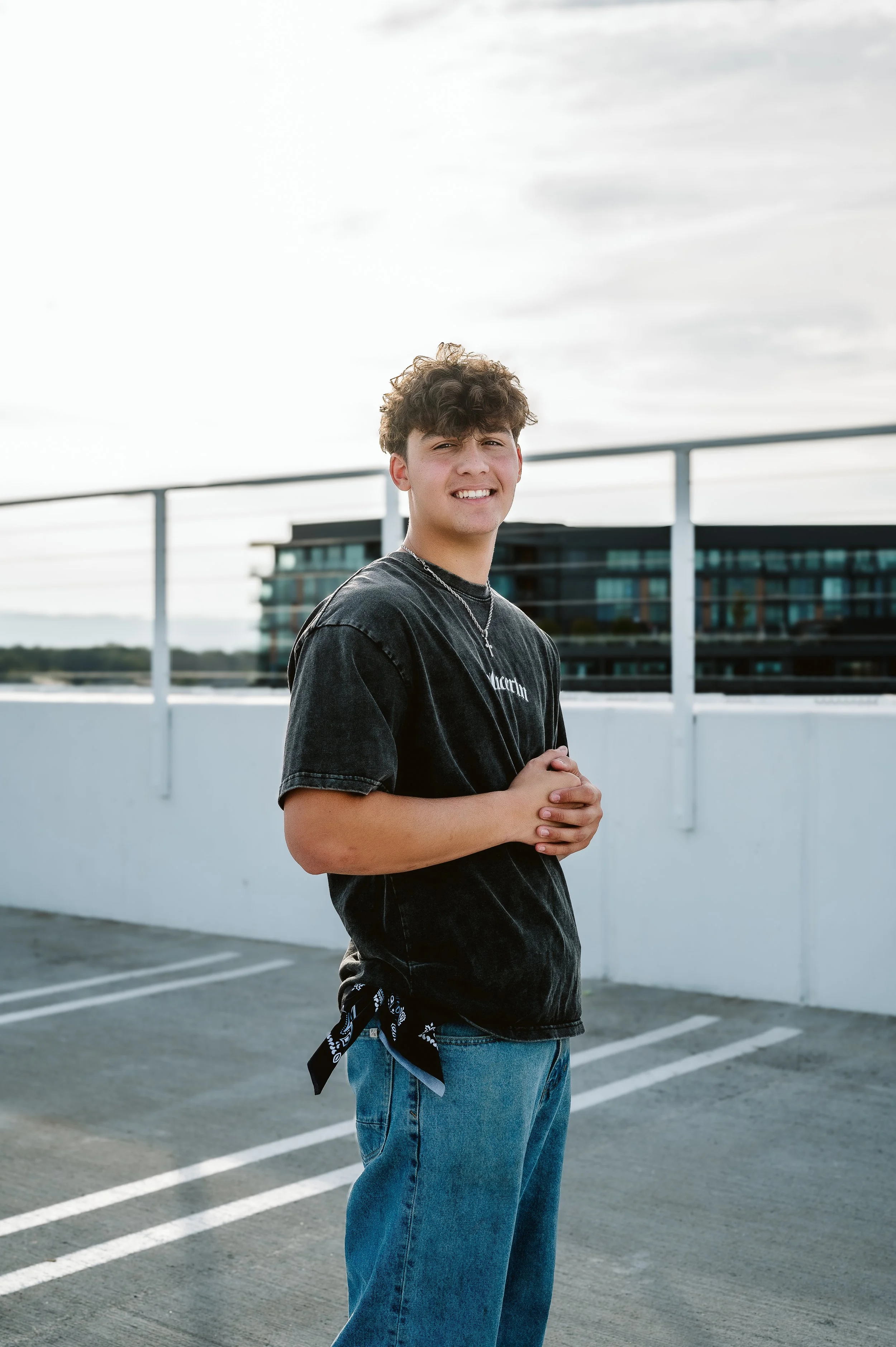 Male high school senior in jeans and a black shirt during an urban senior photo session in Vancouver WA