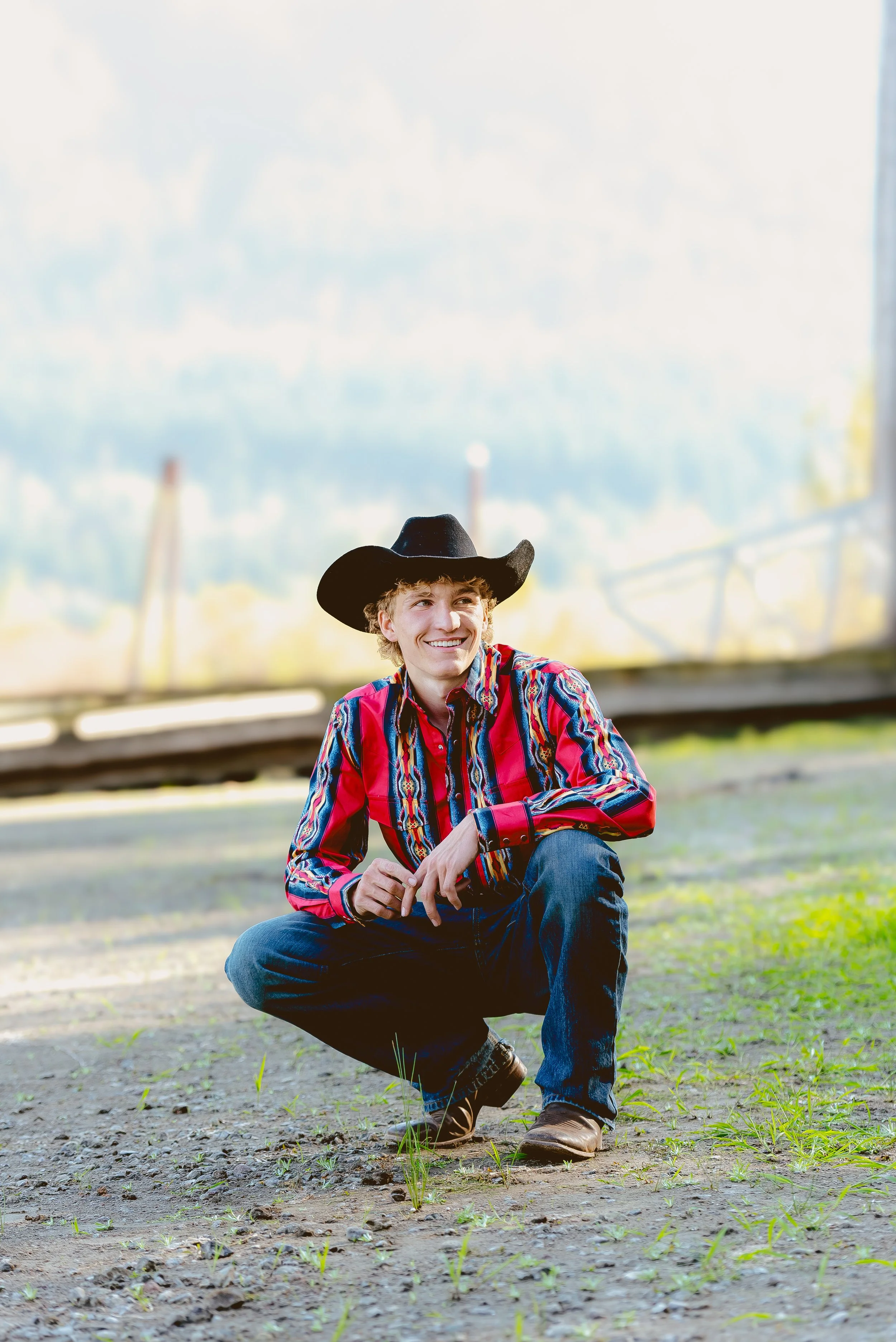 High school senior wearing a cowboy hat and western shirt during an outdoor senior photo session in Vancouver WA