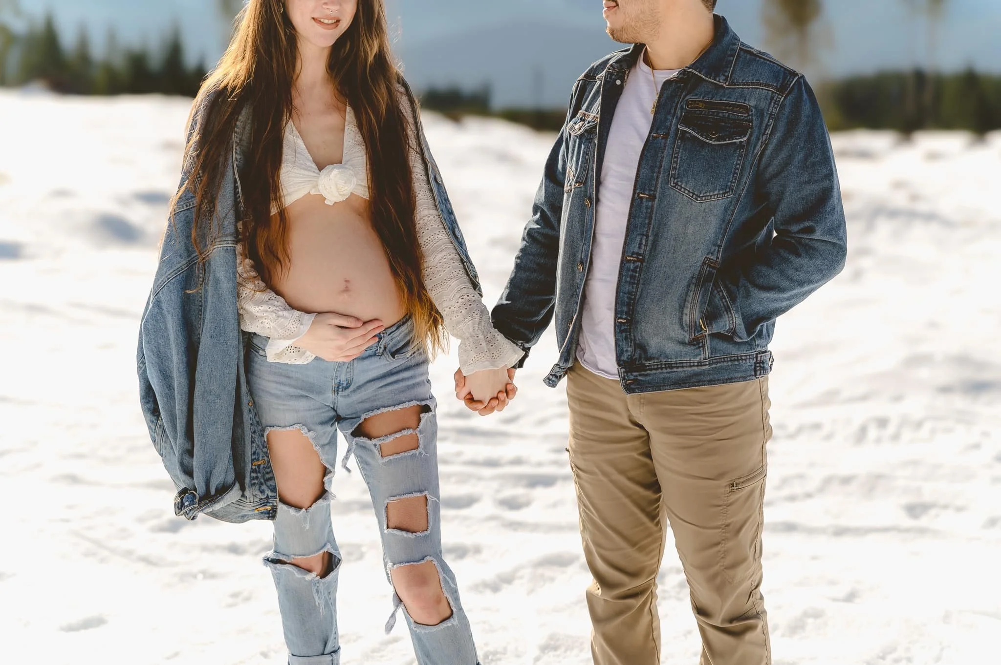Pregnant mother wearing denim jeans and jacket during a winter maternity photo session in Vancouver WA