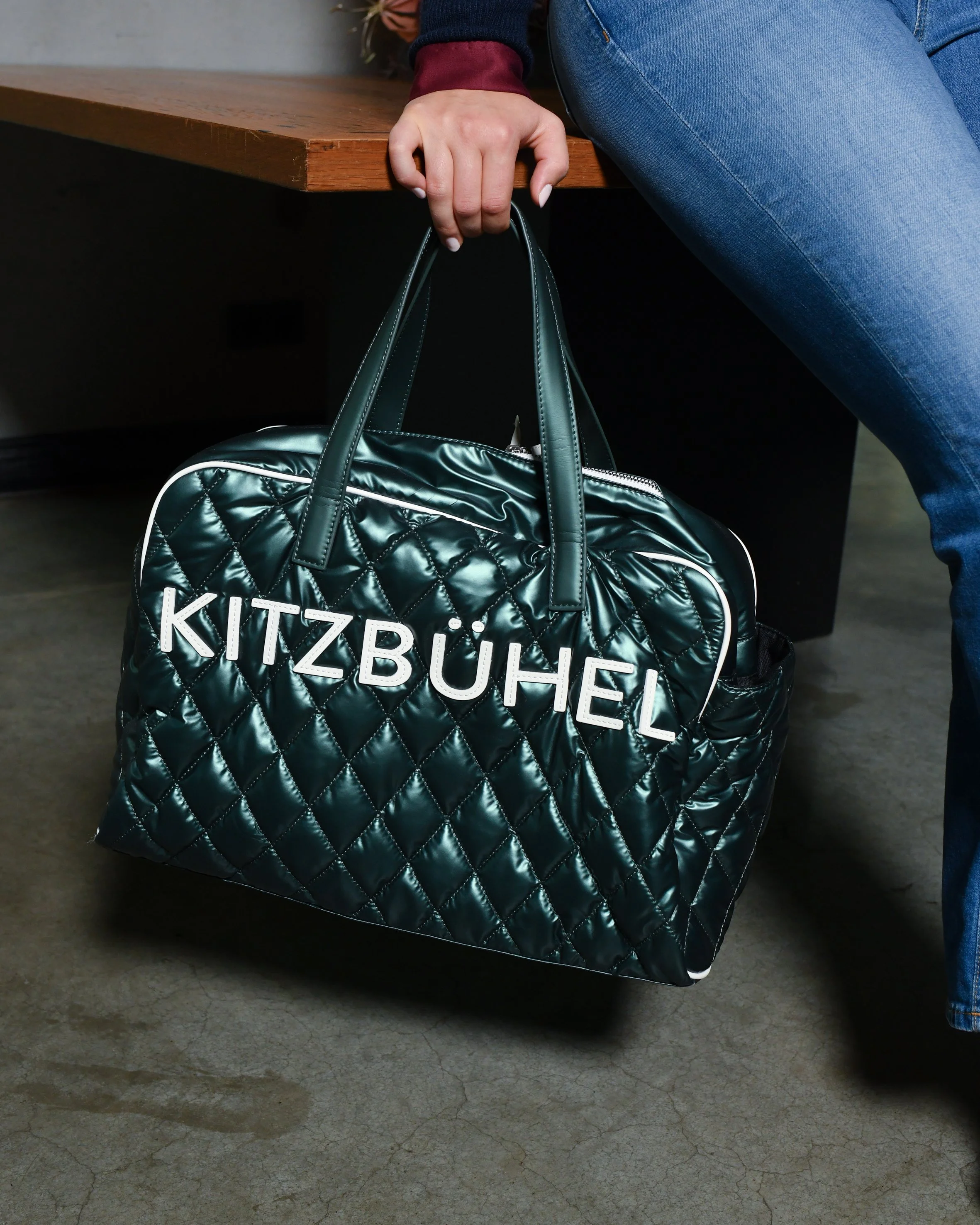 Türkis-grüne Tasche, auf der Kitzbühel steht.