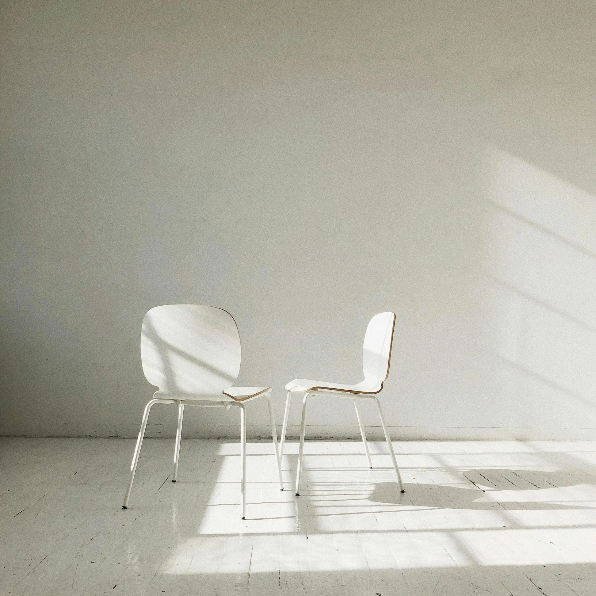 two modern chairs in sun lit photography studio