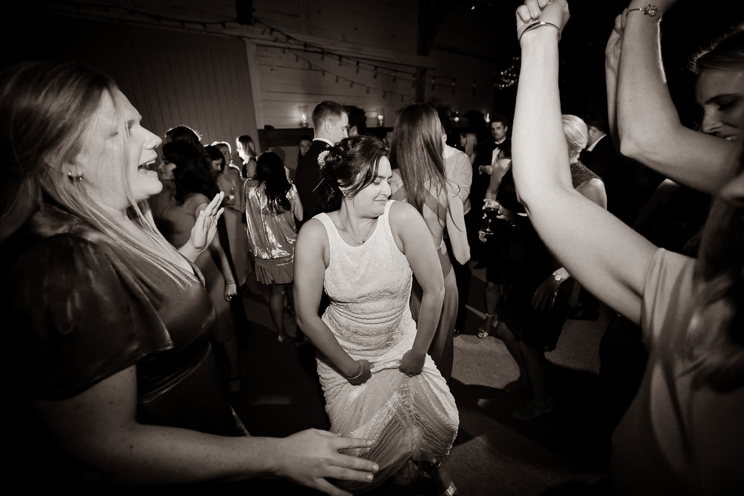 People dancing and enjoying themselves at a party or celebration in a dimly lit room.