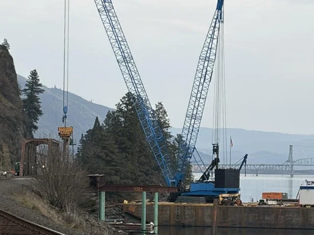 A construction crane with the Hood River Bridge in the background