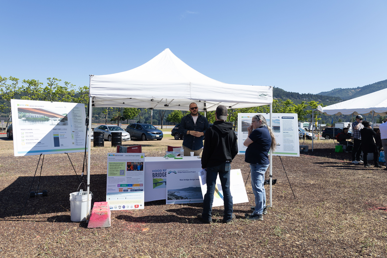 a Hood River-White Salmon Bridge Project table with event attendees having a conversation