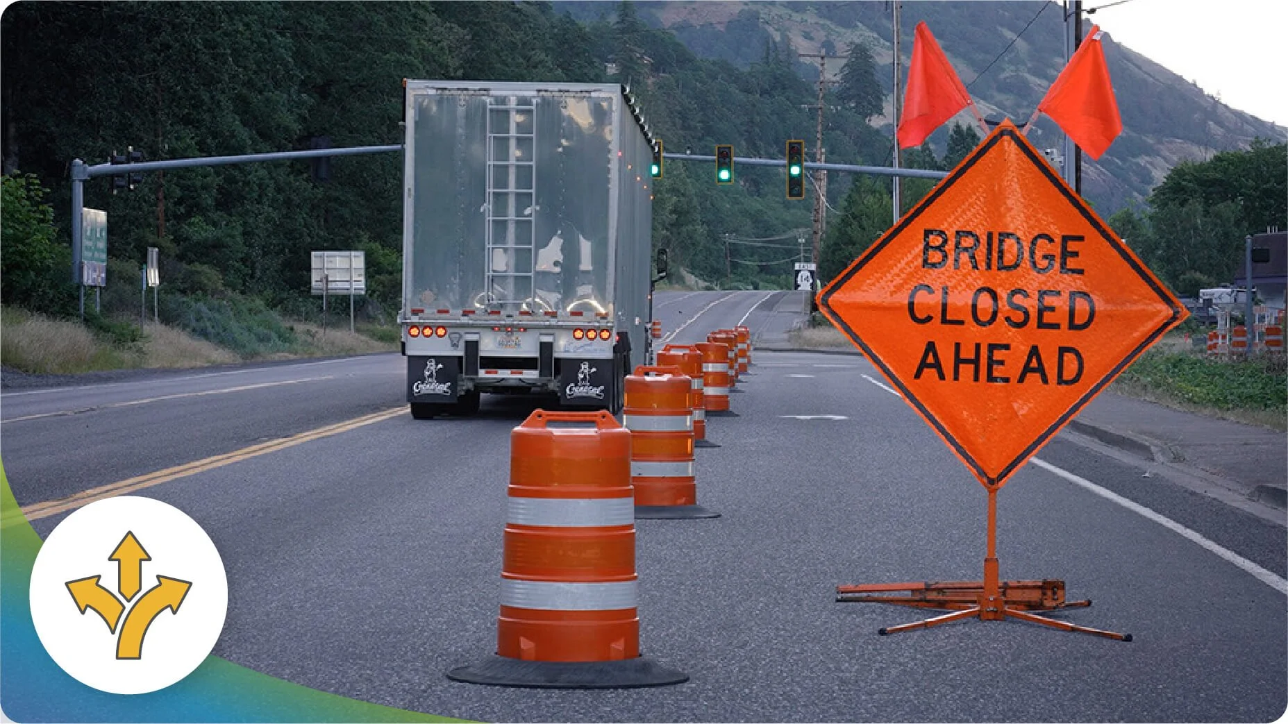 Road sign that says “Bridge Closed Ahead” on a road with a lane closed. 