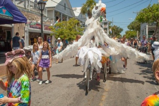 Students and teachers use pedal-power to propel their larger-than-life Peace Dove down Duval Street.  