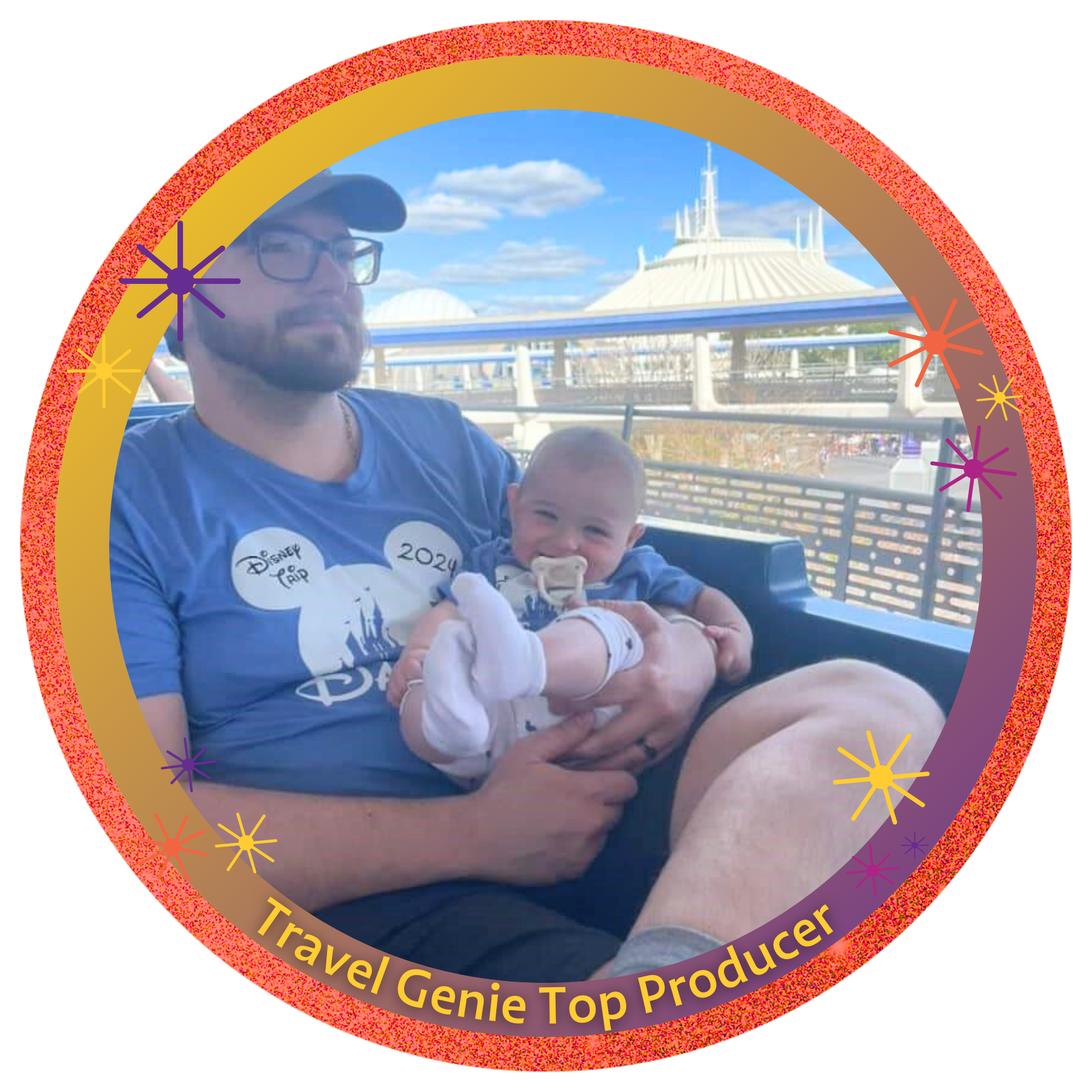 A smiling man with glasses and a beard, wearing a blue Disney-themed cap and a colorful Hawaiian shirt with Disney characters, standing with arms crossed on a balcony overlooking a river and buildings.