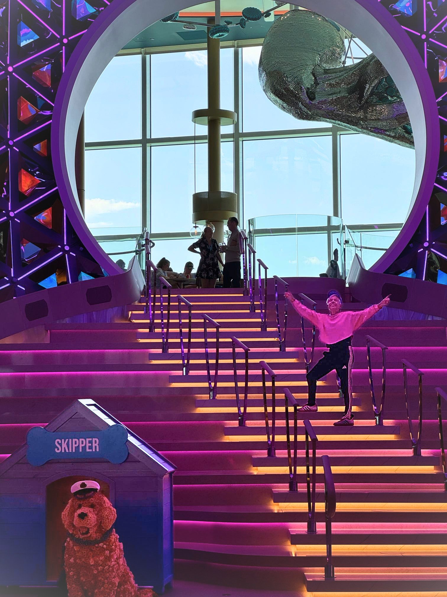 Woman standing on the stairs of the pearl, the hub of the action on the legend of the seas cruise ship