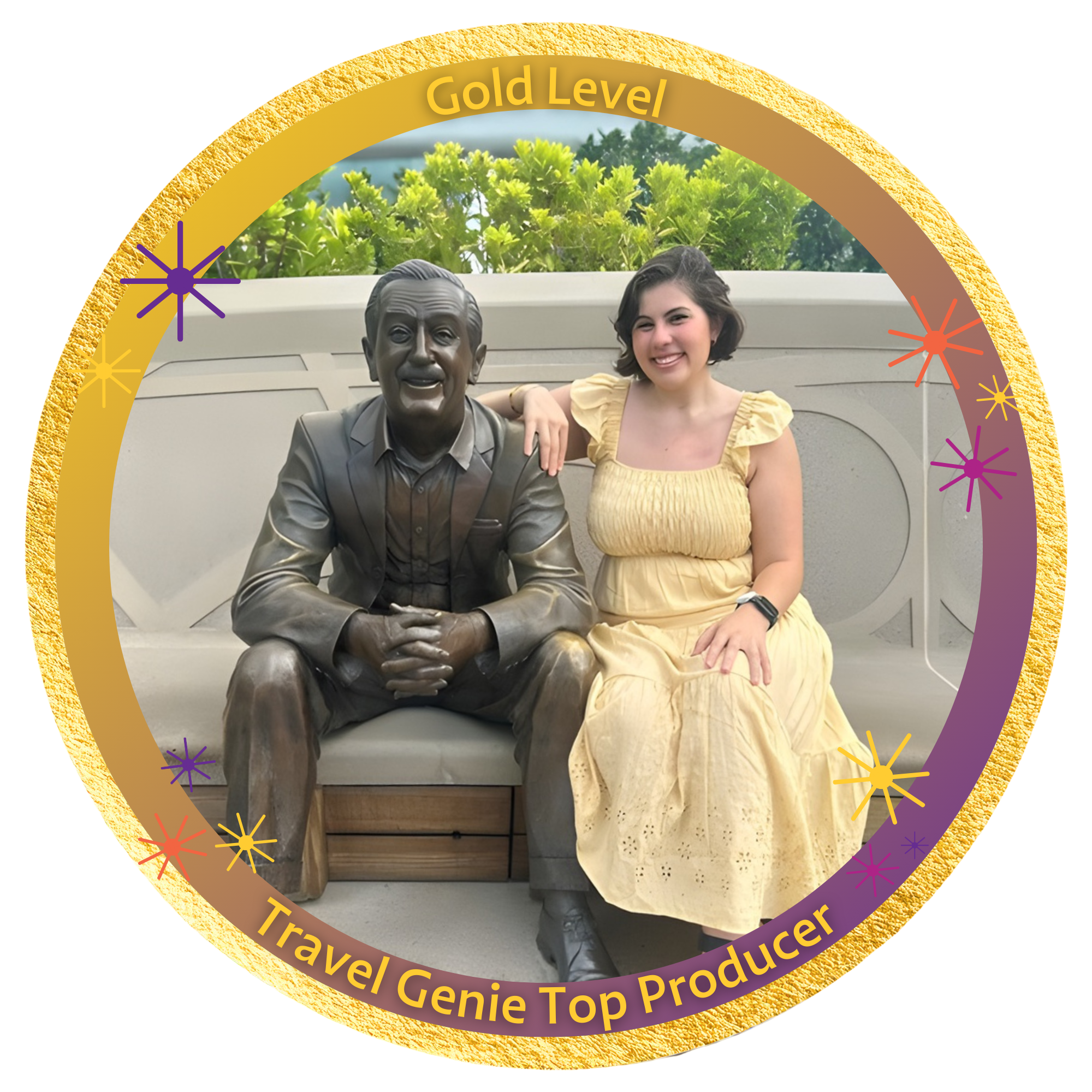 A young woman with short dark hair smiling and sitting next to a bronze statue of a man in a suit, on a stone bench outdoors with greenery in the background.