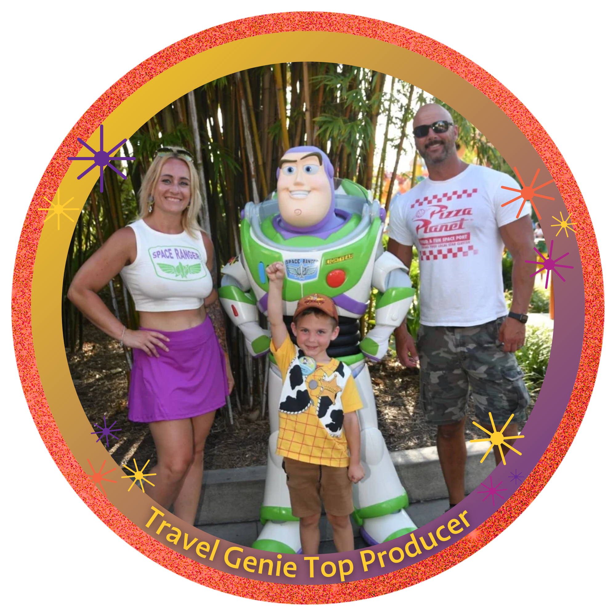 A family of three posing with Buzz Lightyear statue at an amusement park. The woman is wearing a crop top and purple skirt, the man is in a white t-shirt with red text and camouflage shorts, the boy is wearing a yellow shirt with cow print and a sheriff badge, all smiling outdoors with greenery in the background.