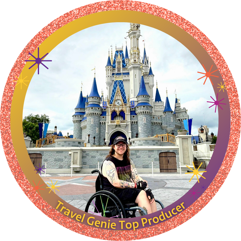Person taking a selfie in front of Sleeping Beauty Castle at Disneyland, wearing a black cap, glasses, and a black tank top, with a tattoo visible on the chest.