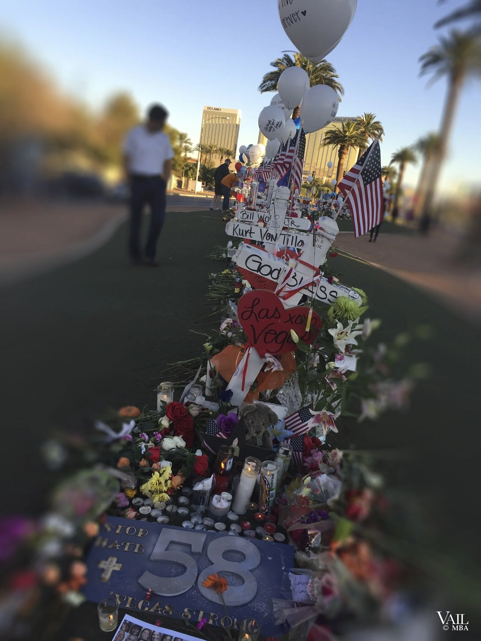1 October memorial with numerous crosses, American flags, balloons, candles, and flowers honoring the 58 victims.
