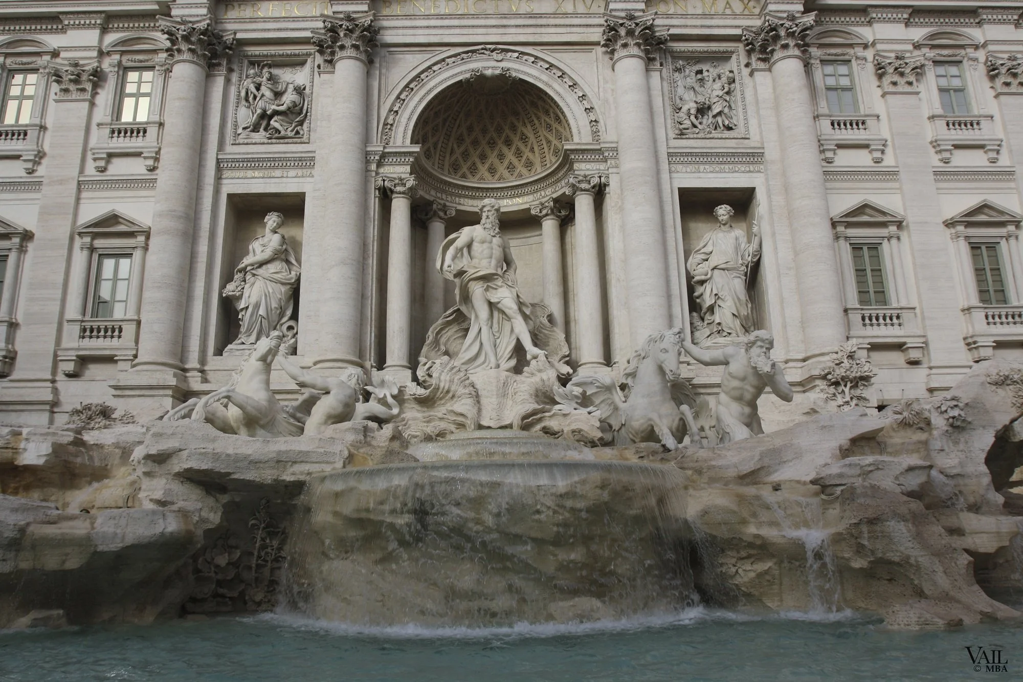 The Trevi Fountain in Rome, Italy, featuring intricate sculptures of mythological figures and a large basin filled with water at the bottom.