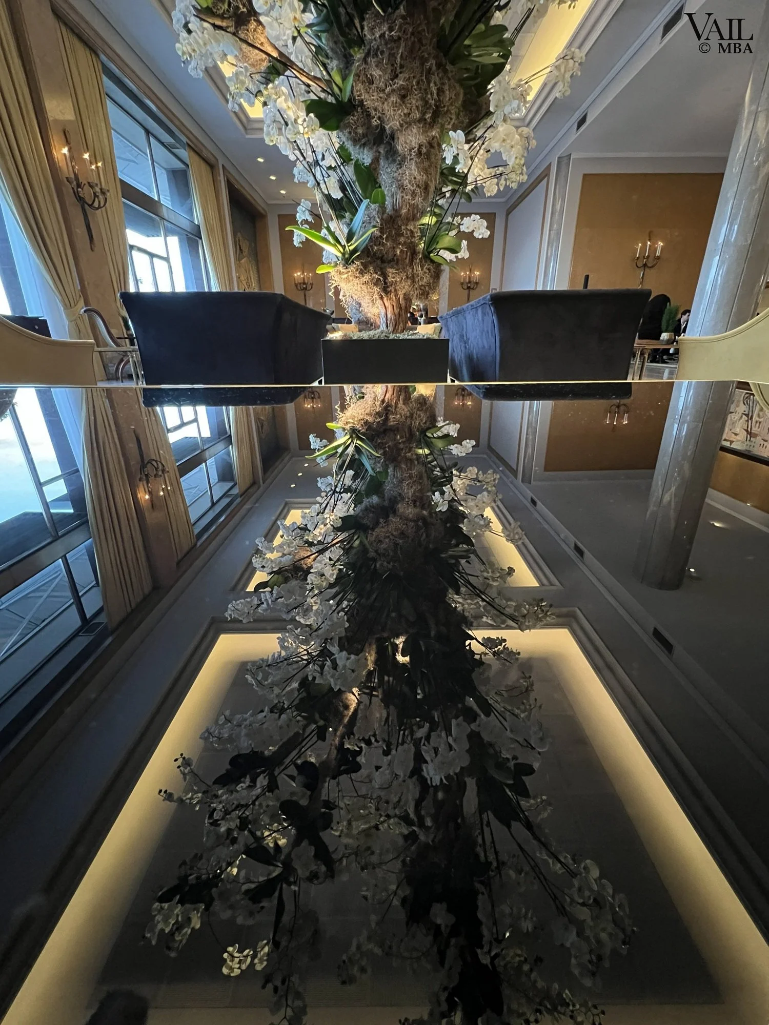 Reflection photo of floral arrangement on a glass coffee table at the Four Seasons Hotel Ritz Lisbon Portugal lobby bar.