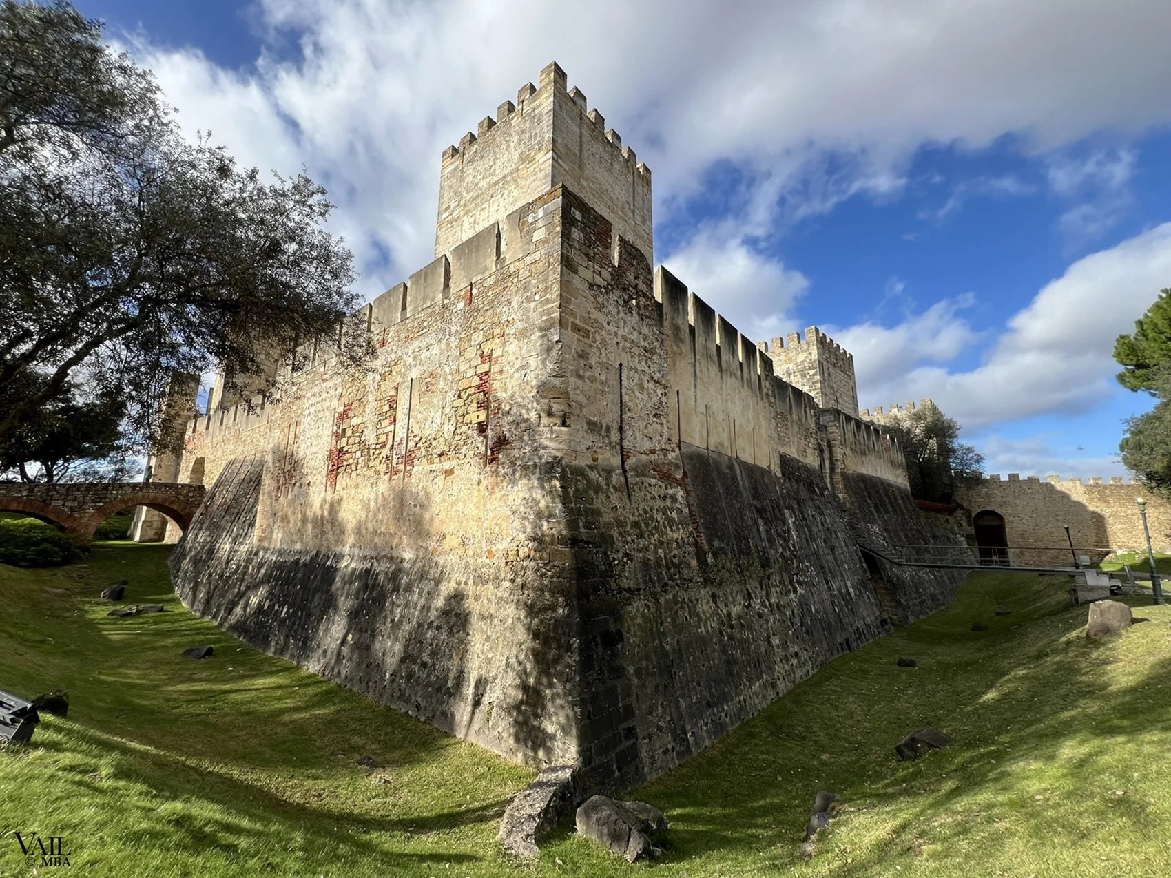 An historic stone castle with a large tower and defensive walls in Lisbon, Portugal.