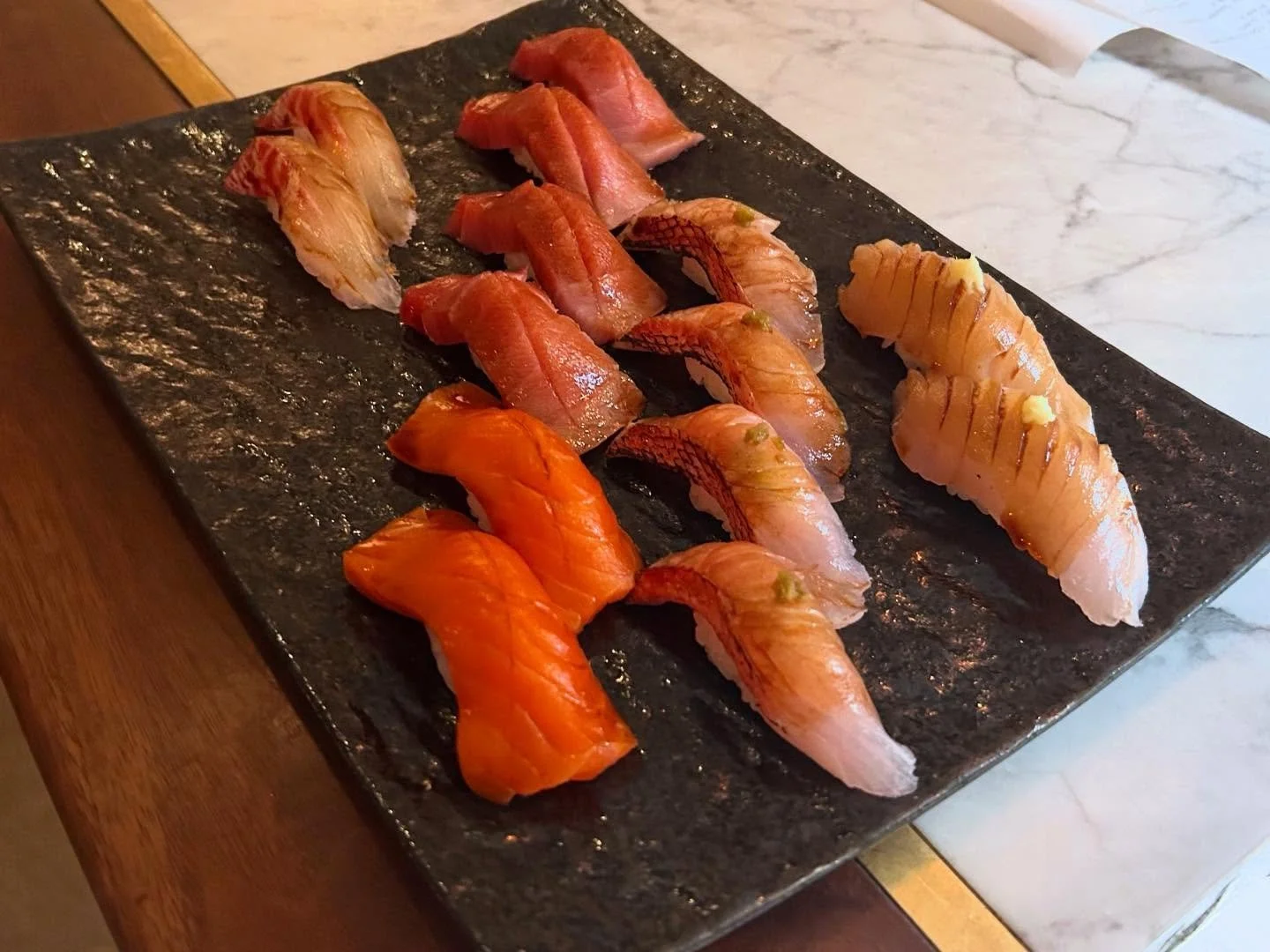 This great plate of market fish features, from Top to Bottom is 2 orders of our Chu Toro, 2 Orders of Kinmedai, and 1 order of our Julie Salmon. On the left we have our Toro Sawara, or King Mackerel, on the right is our Hedai, or gold-lined Seabream.
